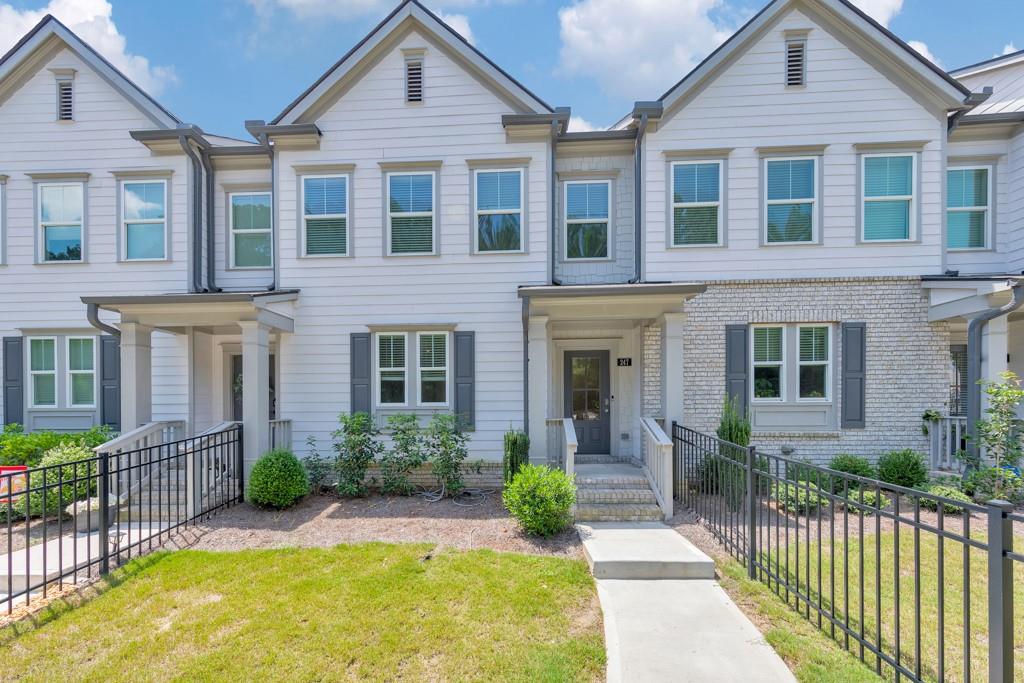 Welcome to this stylish 3 bedroom, 3.5 bathroom townhome in the sought-after Towne Lake Hills community in Woodstock! Investor-friendly with no rental restrictions! Built in 2022, this modern home features crown molding, recessed lighting, and an open-concept main floor perfect for entertaining. The chef’s kitchen is equipped with white cabinetry, stone countertops, stainless steel appliances, a pantry, and a center island with seating. Enjoy cozy evenings in the fireside family room or step out onto the rear deck for fresh air. Upstairs, the spacious primary suite includes a walk-in closet and a spa-like ensuite with double vanities and a sleek glass shower. Two secondary bedrooms share a full bath, and a convenient laundry closet is located on the upper level. The terrace level adds flexible space with a full bathroom, bonus room, and access to the attached 2-car garage. A fenced front yard and unbeatable location just minutes from Downtown Woodstock and Noonday Creek Trail make this home a true gem.