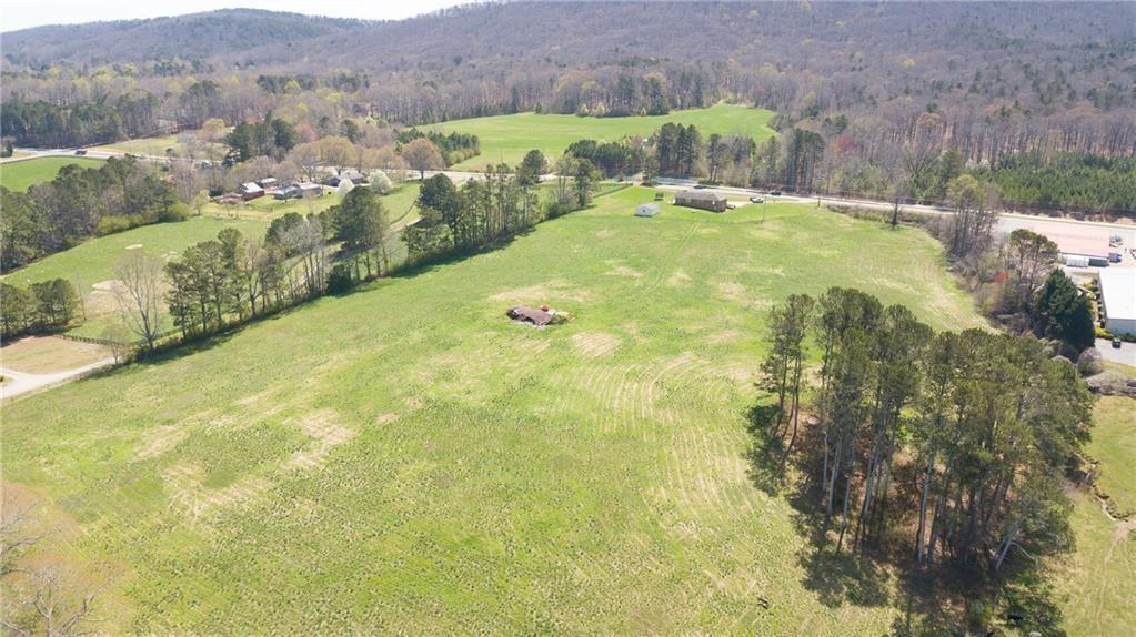 t's Dream Come true to get to live in this Heaven on Earth! Wake up to the Absolutely gorgeous views of Sawnee Mountain and Location and landscape could not be more perfect! only a few miles to downtown Cumming! 12.67 Acres of beautiful, fenced land ideal for privacy or a small farm. Farmhouse with wrap around porch, features owners suite on main level. Saltwater pool, Pool House and 6 Stall Barn round out this stunning property