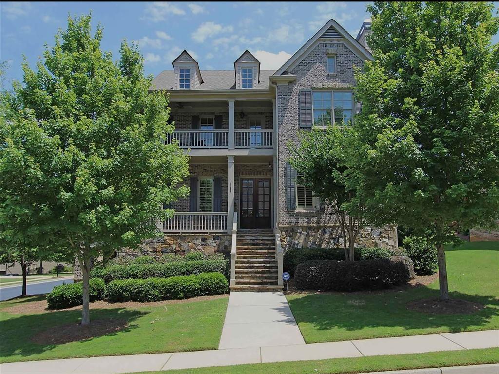 Elegant 4-sided brick & stack stone beauty with 3 levels of living space on a serene corner lot in Smyrna's best kept secret neighborhood. This 5BR/4BA home features not one, but two inviting wraparound porches, perfect for morning coffee or evening unwinding. Inside, a formal living & dining room lead to a spacious eat-in kitchen with breakfast area, open to the fireside family room. Main-level guest suite offers flexibility. Upstairs, the Estate sized primary retreat boasts a sitting area with fireplace, dual walk-in closets, a cedar closet, and a spa-like bath. Three additional bedrooms share a wide, light-filled hallway. Unfinished basement with side-entry garage door is ready for your custom vision. HOA-maintained lawn. Moments from shopping, The Battery, and I-285. 3-car garage.