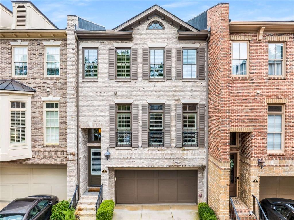 CANDLER GROVE TOWNHOMES IN DECATUR: Brick, Fee Simple Townhome with natural light flowing through floor to ceiling windows with transoms and abundant quality finishes: solid oak site-finished hardwood flooring throughout, coffered ceilings, cove molding, wooden interior shutters throughout, and recessed lights. Candler Grove is a small community of 23 townhomes centered around a common green space, located a few blocks from downtown Decatur/ Decatur Square, Clairemont Elementary School, Glenlake Park and Pool, and the MARTA train station. City of Decatur schools are rated among the best in the state. Great room includes the family room, the kitchen, and a breakfast area. Family/ keeping room has built-in bookcases, a fireplace with gas logs, and a wall of windows and French doors. Open kitchen boasts stainless steel Viking Professional appliances (6 burner gas cooktop, in-wall convection oven, bottom freezer refrigerator, dishwasher, built-in microwave), exterior venting hood, walk in pantry, pendant lights, under cabinet lighting, classic Shaker style wood cabinetry, bar seating. Private deck with custom retractable awning runs the entire width of the townhome. Separate living room could easily function as a distinct library/ home office space. Formal dining room. Primary bedroom suite has hardwood floors and a large custom walk-in closet. Primary bathroom features double vanities, a jetted tub, a separate shower, and a separate water closet. 2 additional upper floor bedrooms, also with hardwood floors, share a full bathroom. Laundry room is located on the upper (bedroom) floor. Large lower floor bedroom has access to a full bathroom as well as a patio. Entry hall on lower level has bench seating with storage and hooks. Two car garage with electric car charger. New roof in 2023. The City of Decatur is conveniently located on a MARTA train line with its own station. Decatur’s proximity to Emory and the CDC attracts talent from all over the world. Midtown and Downtown Atlanta are nearby as well. The City of Decatur school system is renowned for excellence. Decatur is host to numerous yearly festivals and events, e.g. Decatur Book Festival, Decatur Beach Party.