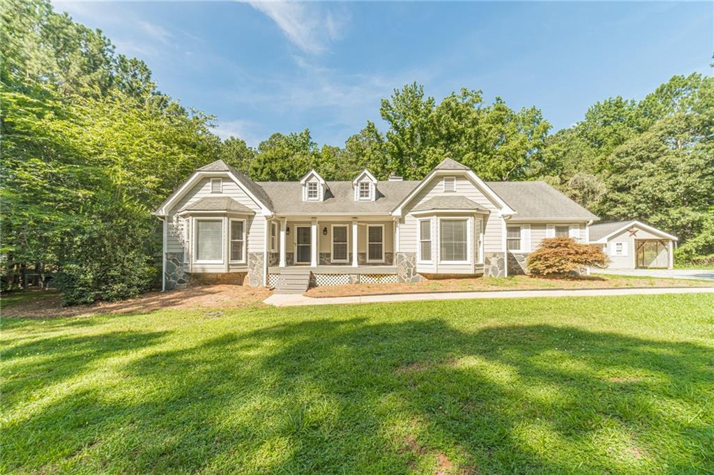 Welcome to 4120 Grady Smith Rd in Loganville, GA on 7+ Acres a beautifully updated ranch home nestled in 7+ wooded acres perfect for all your outdoor activities in the sought-after Bay Creek Elementary and Loganville High School districts. This spacious 4-bedroom, 2.5-bath home features new LVP flooring throughout, fresh paint, updated lighting, and a brand-new HVAC system for year-round comfort. The kitchen is updated with an eat at island, stainless appliances, painted cabinets, and granite countertops. The master on the main has a large walk in closet, updated shower, dual vanity, and a garden tub. The main floor includes 2 additional bedrooms, a half bath, an additional full bath, breakfast room, and a separate dining room. The partially finished basement includes a bedroom that can be used as a flex space, media room, gym, or office. The basement also includes an additional room with a pet bathing station. Enjoy the convenience of a 2-car garage plus a detached shop with an additional one-car carport perfect for hobbies, storage, or extra parking. With peaceful surroundings and modern updates, this property is the perfect blend of privacy and functionality.