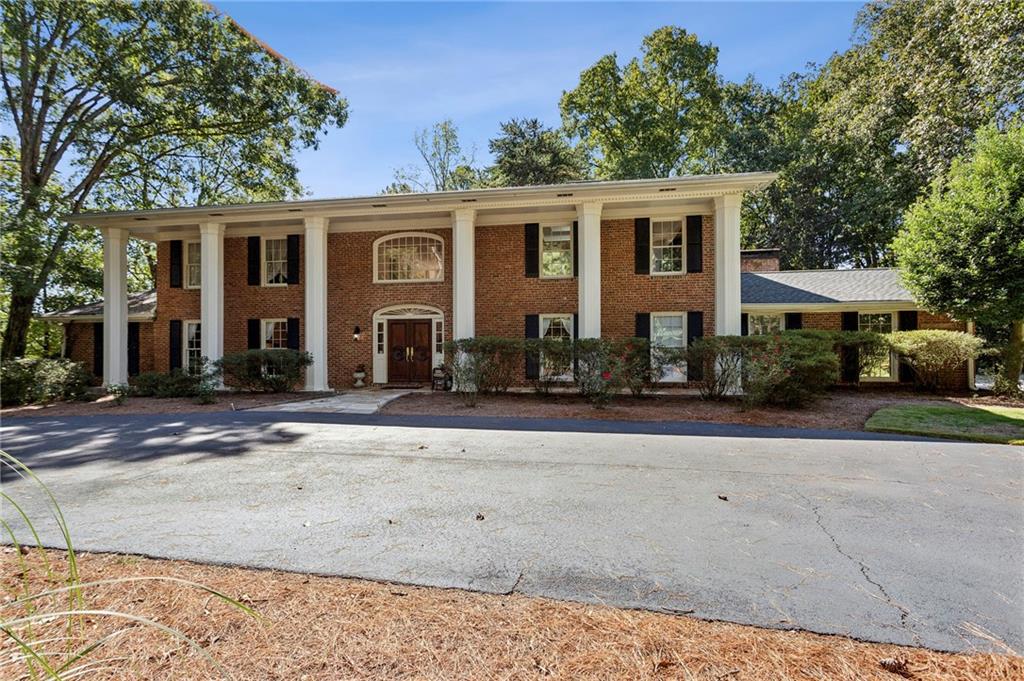 An exceptional opportunity to enjoy privacy and sophistication inside the perimeter! Tucked away on a serene, wooded acre+ lot, this distinctive residence was designed for the buyer who values individuality over “cookie cutter.” A dramatic two-story marble foyer with a sweeping double staircase sets a glamorous tone from the moment you enter. Beautifully maintained and thoughtfully updated, the home features generous entertaining spaces including a large kitchen with a butcher-block island open to the family room, screened porch, and expansive deck overlooking the sparkling pool. Walls of windows and French doors flood the home with natural light and create a seamless connection to the lush outdoor setting. The flexible floor plan easily accommodates multi-generational living with three finished levels and an elevator. Upstairs, two bedrooms were combined to create a luxurious primary suite with a spa-inspired bath and spacious custom closet. The light-filled terrace level offers direct access to the pool and gardens, perfect for relaxed gatherings. Situated on a quiet cul-de-sac, this special property offers walking paths, perennial gardens, and an extraordinary sense of privacy—truly a one-of-a-kind retreat just minutes from everything Atlanta has to offer.