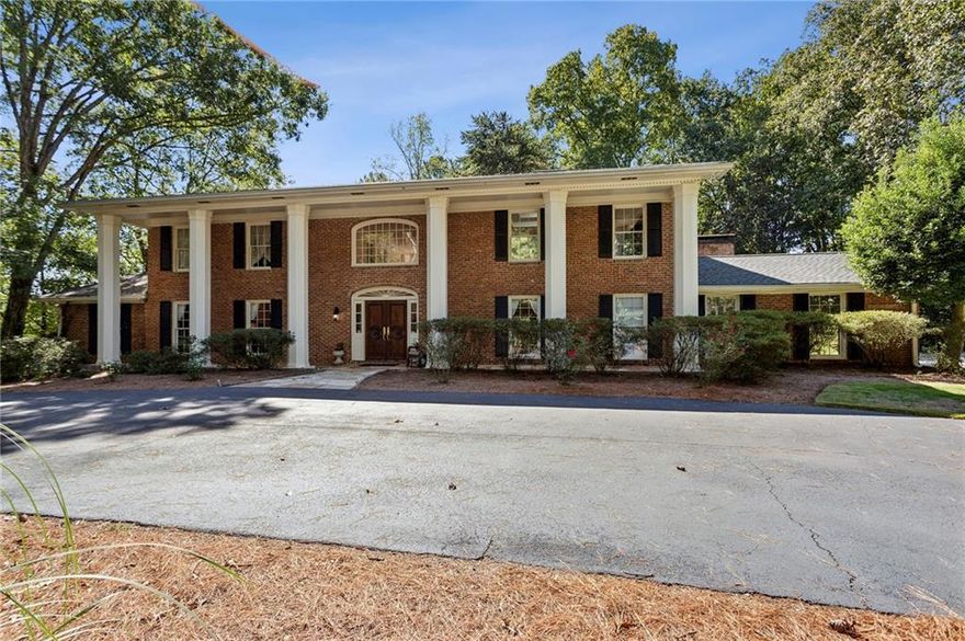 An exceptional opportunity to enjoy privacy and sophistication inside the perimeter! Tucked away on a serene, wooded acre+ lot, this distinctive residence was designed for the buyer who values individuality over “cookie cutter.” A dramatic two-story marble foyer with a sweeping double staircase sets a glamorous tone from the moment you enter. Beautifully maintained and thoughtfully updated, the home features generous entertaining spaces including a large kitchen with a butcher-block island open to the family room, screened porch, and expansive deck overlooking the sparkling pool. Walls of windows and French doors flood the home with natural light and create a seamless connection to the lush outdoor setting. The flexible floor plan easily accommodates multi-generational living with three finished levels and an elevator. Upstairs, two bedrooms were combined to create a luxurious primary suite with a spa-inspired bath and spacious custom closet. The light-filled terrace level offers direct access to the pool and gardens, perfect for relaxed gatherings. Situated on a quiet cul-de-sac, this special property offers walking paths, perennial gardens, and an extraordinary sense of privacy—truly a one-of-a-kind retreat just minutes from everything Atlanta has to offer.