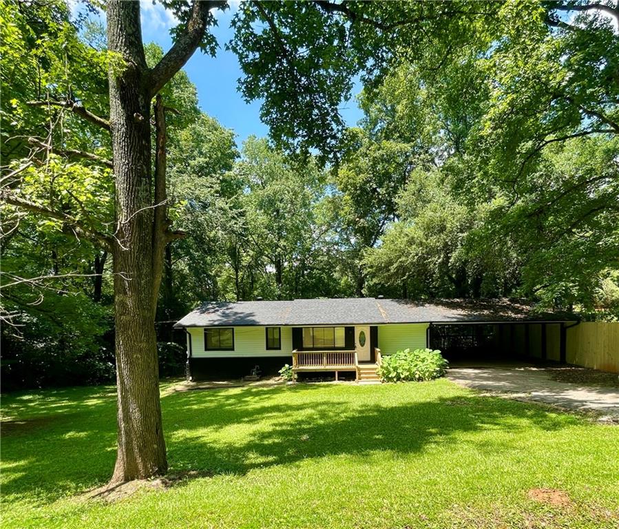 Clayton County Privacy and Convenience! Newly renovated and MOVE-IN-READY! Easy access to Panola Rd/I675. +- .40 ACRE of PRIVACY. This renovated, 4 bedroom/ 2 full bath home features beautifully refinished floors throughout. ALL NEW kitchen granite, backsplash and NEW appliances. New bathroom flooring, vanities, shower tile and toilet. Full length dining room/flex space off the kitchen with new french doors leading to the covered patio. NEW front deck. Very private back yard could be your private oasis in waiting! Full bath and potential second living space in the lower level with separate entrance. Large bedroom and TONS of storage downstairs. OVERSIZED, two area ATTACHED shop space offers two points of exterior entry and SO MUCH POTENTIAL for a home business! EXTRA WIDE covered parking. NO HOA on this quiet street with only a few private residences. No exit access, dead end street. Nice residential area to call home!