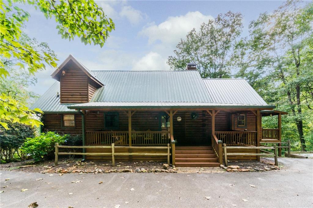 Now is the time to schedule your visit to the NE Georgia Mountains! Thoughts of apples, cooler temps and hints of fall have exploring Dahlonega/Lumpkin County a great adventure. You'll definitely want to include a tour of this amazing 4 bedroom/4 bath home inside Trahlyta Estates! Its impressive features will Wow you at every turn. First, you'll find yourself in a generous, open concept area that includes the kitchen, dining and living rooms. This space is set up perfectly to maximize time together while preparing snacks/meals, eating or playing board games at the table, and relaxing in the sitting area to visit, watch tv or enjoy the fireplace. High-speed internet is also available. To the right is the huge master suite which boasts a connected master bath and closet, second fireplace, and a private balcony. Across the way on the main level, there's another large bedroom which currently has two beds, other furniture and is still roomy enough to easily move around. It also offers a good sized walk-in closet. Next door is a generous, full bathroom with a separate vanity and a walk-in shower. For convenience, you'll find the laundry in this area as well. Continue exploring the home by taking the stairs up to the loft area. When you reach the landing, you'll find a large area outfitted with a chair for reading/relaxing that is also a bed! Tuck away in the corner to have some down time or be a part of the living room conversation from above! But don't forget to check out the superb bedroom as well. It's spacious enough for the bed, furniture and extra space. The room also includes a large closet for storing linens, blankets, etc. The oversized bathroom includes a wide vanity, open space for a chair, drying rack, etc. and a private, walk-in custom shower. The loft definitely adds an enjoyable "Plus" to the home. But there's still a lot more to see. Beside the kitchen, take the stairs to the lower level. There you'll find a new game room complete with a game table, cornhole, and other recreational games. Travel down the hall and you'll find yourself in a substantial open area that includes a roomy den complete with yet another fireplace, a fourth bedroom and another bathroom (which makes #4)! Not only does the den offer a place to hang out, but the sofa and chair can also be converted to sleeping spaces. And as a Major extra bonus, the room has already been plumbed and wired to install a kitchen! The bedroom comes with a queen bed, matching nightstands, and twin trundle beds. The luxury bathroom boasts yet another custom, walk-in shower. As you can see by now, the home's interior is first-class. And then there's the outdoor living features which are not to be outdone. It has to begin with the large front porch that greets you with the invitation to sit and enjoy the flowers and yard. And the porch is so long, there's room to add multiple seating areas. Second is the master suite's private balcony offering an opportunity to slip away and enjoy a quiet cup of coffee in the morning or maybe some much-needed conversation time. The third feature is the expansive, screened-in deck just behind the living room where you'll find plenty of space to entertain your entire group, watch outdoor games below, or enjoy looking out over the back of the property and just take in the sights and sounds of nature. The ground-level patio is our fourth area to explore. It comes complete with a large hot tub, 6-person table and chairs, gas grill, and drink cooler on a rolling stand. Entertaining made easy!. There's spacious sleeping accommodations and parking for at least 6 vehicles. This home comes fully furnished and stocked. The negotiated purchase price of those items will be covered in a separate Bill of Sale. It's "Turn-key Ready" -- primary, secondary, or an income-producing Short Term Rental -- which it has been since 2021. Community features include a pavilion, pond, and newly widened roads with curbing.