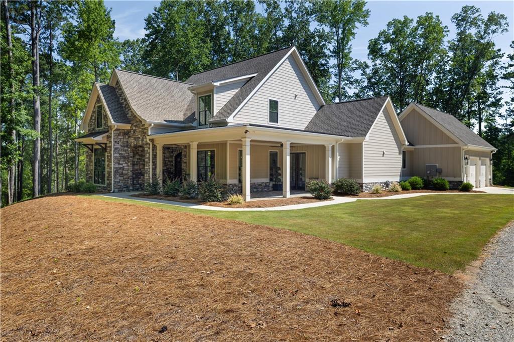Discover refined elegance at this stunning 2023 custom built lake house retreat nestled on 3.5 private acres, offering private access to the stocked Kelley Lake. This sophisticated residence offers seamless one-level living with thoughtfully designed spaces that blend luxury and comfort.
The heart of the home features an open-concept great room with soaring ceilings and exposed beams, flowing effortlessly into a gourmet kitchen appointed with premium finishes, crisp white cabinetry, and a large kitchen island. Natural light floods the interior through expansive windows and french doors leading to the back of the home’s covered patio space fit with a wood burning fireplace and the perfect view over the lake for your summer grilling activities.
The main level encompasses a luxurious master suite with dual walk-in closets and a spa-inspired bathroom featuring a soaking tub, glass-enclosed shower, and elegant solid surface accents. Two additional bedrooms complete the upper level, perfect for guests or family. Your fourth bedroom can be utilized as a guest on suite on the main or used as an office as the current owners have done. Come and enjoy your getaway and call 1282 Dean Hill Road your next home!