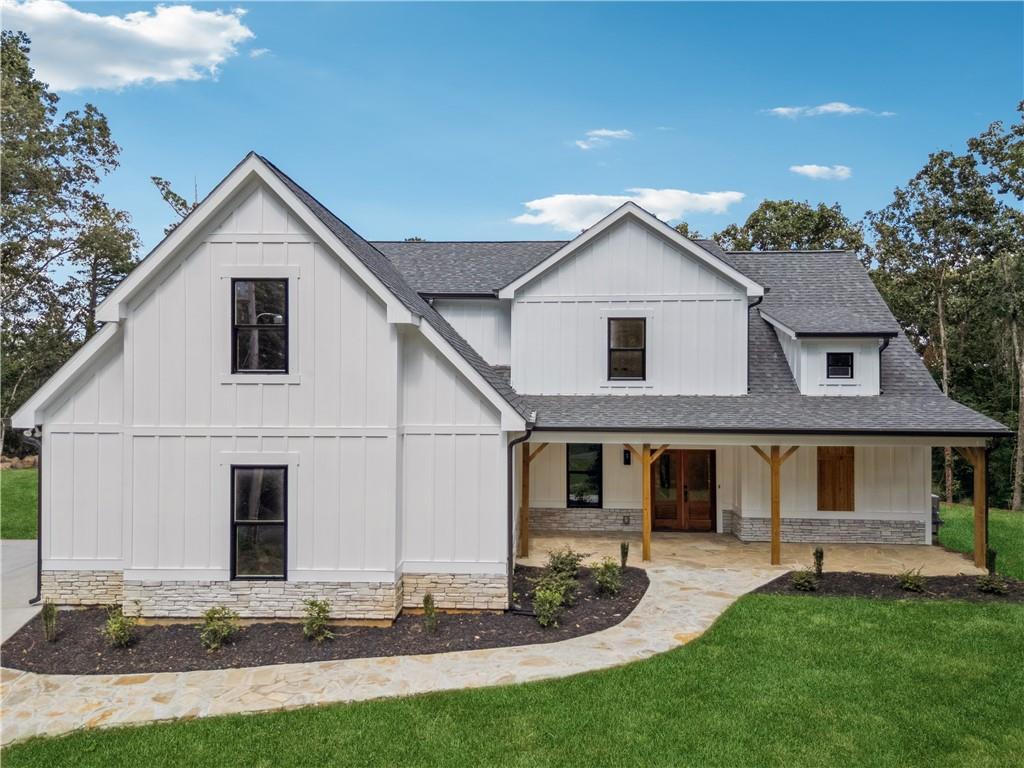 Don’t miss the opportunity to live in this NEWLY BUILT GEM, located in the heart of Woodstock. Situated on a quiet cul-de-sac with NO HOA, this residence offers privacy, style, and convenience—just 5 minutes from vibrant Downtown Woodstock, with easy and quick access to Alpharetta and Roswell, with an excellent school district, including the highly regarded RIVER RIDGE HIGH SCHOOL. A rare combination of location, design, and value in one of the area’s fastest-growing communities.
Designed with a modern ranch-style layout, this home features a unique floor plan that opens with a spacious foyer leading into a vaulted great room and open-concept kitchen with soaring 16-foot ceilings that enhance the natural light and open feel. The kitchen is equipped with custom cabinetry, quartz countertops, a center island, gold-tone fixtures, and stainless-steel appliances.
The Master Bedroom is located on the main floor and offers a spa-like bathroom with double vanities, a separate shower and tub, and a walk-in closet. In total, the home includes four bedrooms, three full bathrooms, and one-half bath. The second level features 9-foot ceilings and well-designed spaces ideal for family or guests.
Enjoy over 1,000 square feet of covered porches overlooking a wooded view—perfect for outdoor living and entertaining, providing a total built area of 4051 sqft. The property also features an ELJEN septic system, known to have a durability of up to 100 years.