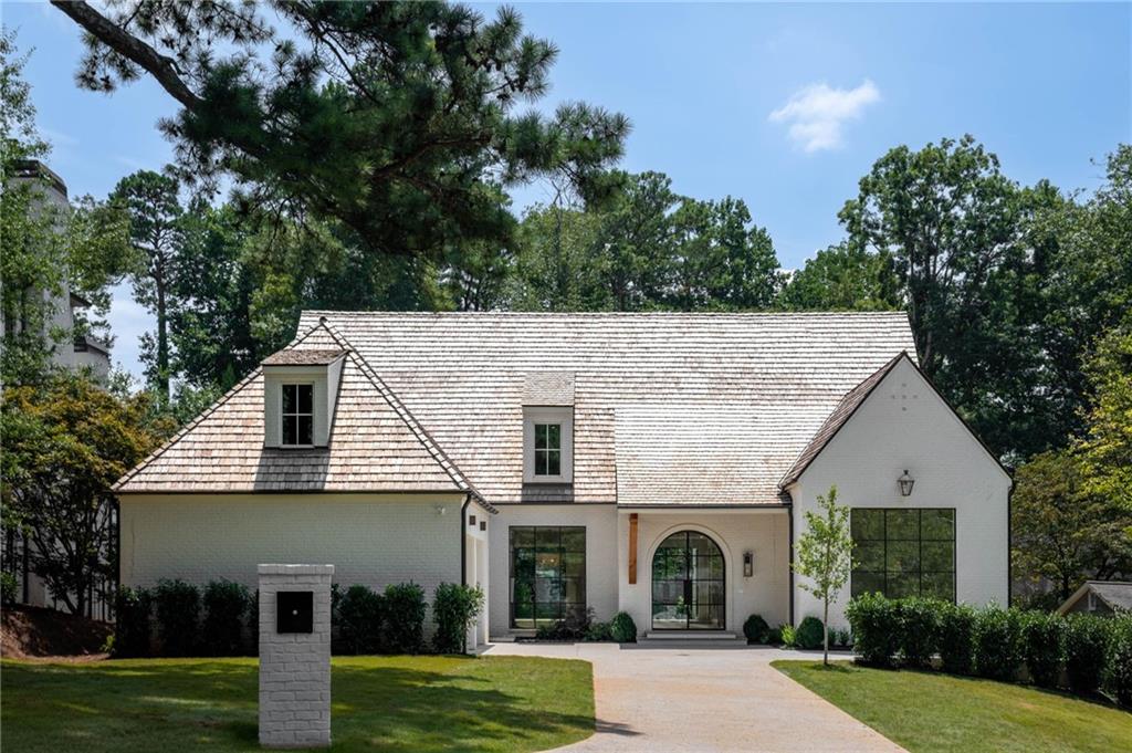 Another beautifully crafted new construction home by Siegel Construction & Design! 4 Bedrooms/4 Baths/3 Half baths located on a quiet, cul-de-sac street in desirable Chastain Park neighborhood. Large open floor plan with clean lines, unique accents and bright living spaces. Other special features include iron windows, wide staircases, oak beams and 4" white oak floors. Kitchen includes custom cabinetry, mystery white marble countertops/backsplash, Wolf Range oven, custom plaster vent hood, and unlacquered brass hardware. Working pantry off of the breakfast room includes custom iron cabinets, panel front appliances and handmade Zellige tile. The main level has a walk-out turfed backyard with a pool, as well as an outdoor covered porch with a masonry fireplace and gas grill. The primary suite is located on the main level and has separate walk-in closets, and iron french doors that open to the pool area. Full size laundry room on main includes built-in cabinet lockers, and there is an additional laundry room on the second floor. The finished terrace level includes a fitness room, large bonus room/playroom with a wet bar, and unfinished space that is stubbed for a future bedroom suite. Additional unfinished space on the terrace level could be used for a media room, office, golf simulator, etc! Exterior includes bluestone patio, cooper gas lighting, cedar beams, and a cedar shake roof. Fenced grass yard area located behind the pool for pets/garden or playing. Approximately 1/4th of a mile from The Chastain restaurant, Chastain Park amphitheater and Chastain Golf course!