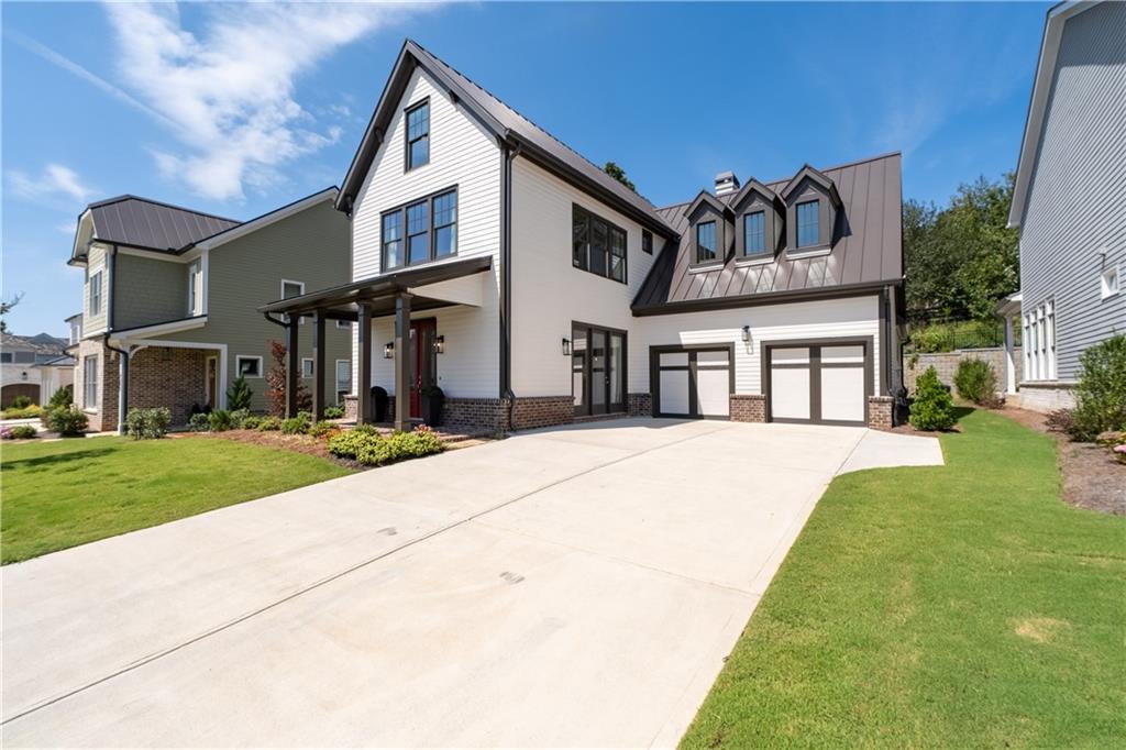 Special buyer opportunity! Ask about qualifying for a 5% APR with our preferred lender—a rare find in today’s market! Step into timeless style and modern comfort in this beautifully designed 5-bedroom Vickery home, where thoughtful details and flexible spaces meet everyday luxury. The primary suite on the main level offers a peaceful retreat, while the upstairs junior suite—with built-in workspace—can easily flex as a media room, second office, or guest hideaway. From the moment you enter, you're welcomed by a formal dining room wrapped in tongue-and-groove planked walls, with a dramatic cast concrete fireplace surround and custom built-ins adding character and charm. The chef’s kitchen is a true standout—featuring a 36-inch Wolf gas range, designer exhaust hood, soft-close cabinetry that reaches the ceiling, quartz countertops with waterfall island, and a custom walk-in pantry with wood shelving that blends form and function effortlessly. In the great room, exposed brick walls and a cozy fireplace set a warm, inviting tone. French doors lead to the covered brick patio, where soaring ceilings and a waterfall feature create a one-of-a-kind outdoor escape—ideal for relaxing or entertaining year-round. Upstairs, you’ll find four additional bedrooms, each with private en-suite baths. One could serve as a private office, while the other bedrooms offer flexibility. Located in the heart of Vickery, just a short stroll to Vickery Village’s shops, dining, and community green spaces, this home truly has it all. Schedule your tour today and fall in love with where luxury, comfort, and convenience come together.