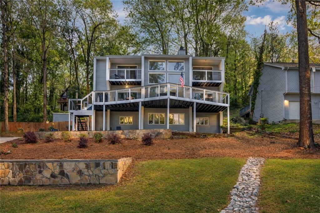 Back of property featuring a deck, a chimney, and a yard