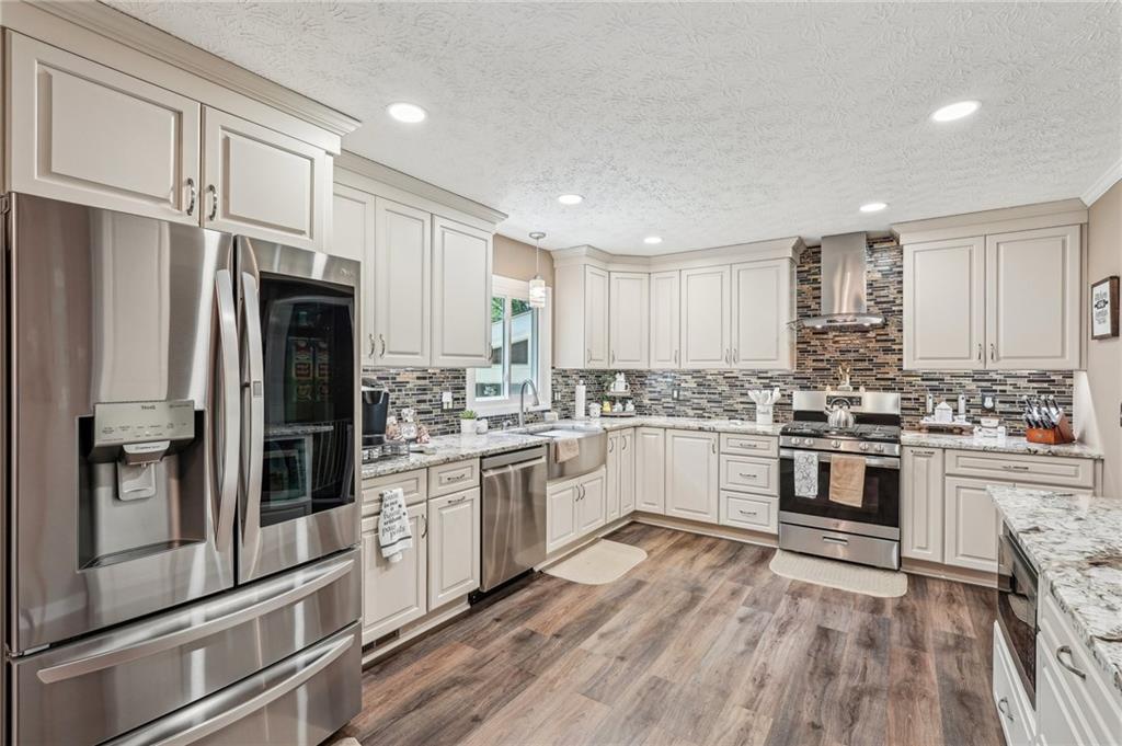 ***NEW ROOF***
This well-located home, just minutes from Town Center and Sprayberry High School, offers a perfect blend of comfort and style with 4 bedrooms and 2.5 bathrooms. Renovated in 2021, this home is move-in ready.
The spacious main level features an updated kitchen that seamlessly connects to the living and dining areas, creating an inviting atmosphere for family gatherings and entertaining. The kitchen is equipped with granite countertops, stainless steel appliances, and 42" cabinets, offering plenty of storage. Thoughtful touches, like a spice rack next to the stove and a dedicated K-cup drawer for your coffee station, make it both functional and convenient. Under-cabinet LED lighting and recessed lights provide a bright, airy feel, while the large island adds extra storage and a microwave cabinet. Durable LVP flooring on the main level is waterproof and scratch-resistant, ensuring long-lasting durability.
The dining room provides easy access to the large, fenced backyard, perfect for outdoor activities. Enjoy relaxing or entertaining on the 15x15-foot deck, or unwind in the separate screened-in porch featuring a ceiling fan and LED lighting, offering year-round comfort.
The lower level is equally impressive, featuring a cozy family room with a stone fireplace and ample natural light. This level also includes a fourth bedroom, which could easily serve as a guest suite or home office, a bonus room, and a half-bath for added convenience. The laundry room is located here as well.
Upstairs, the primary suite offers a peaceful retreat, while two additional spacious bedrooms and a full bathroom provide plenty of room for family or guests. The upper level is finished with beautiful hardwood floors, adding warmth and character to the home.
This well-maintained property is larger than it appears and offers generous living space for a growing family. With recent renovations and thoughtful details throughout, it’s a home you’ll want to see in person to truly appreciate its full potential.