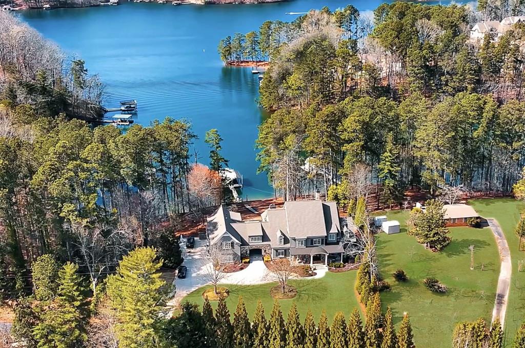 Hamptons-Inspired Luxury on Lake Lanier - Deep Water Estate Between Flowery Branch & Gainesville Discover unmatched lakeside elegance in this custom-built, fully furnished six-bedroom estate, ideally situated on deep water in the sought-after Oakwood area. Drawing from classic Hamptons architecture and designed with modern sophistication, this home offers an effortless blend of timeless style, luxurious amenities, and panoramic views of Lake Lanier. The open-concept layout centers around a tranquil main-level owner's suite that captures serene lake vistas and offers a spa-inspired retreat with a six-foot soaking tub, dual-head oversized shower with body sprayers, and upscale finishes that evoke a true sense of relaxation. At the heart of the home lies a showstopping gourmet kitchen, outfitted with a Wolf 8-burner range with double ovens, Sub-Zero refrigerator, Bosch dishwasher, and an additional fully appointed prep kitchen featuring a second Wolf oven, warming drawer, and Sub-Zero freezer making it ideal for entertaining on any scale. Throughout the home, luxury and attention to detail shine through custom cabinetry, elegant built-ins, plantation shutters, remote-controlled blinds, Sonos surround sound, detailed trim work, and classic shiplap accents. An elevator and ADA-compliant features ensure easy accessibility across all levels, making the home as functional as it is beautiful. Step outside to your private resort-style oasis, complete with a heated saltwater pool featuring an in-floor self-cleaning system, an oversized spa, a vaulted screened porch, new TREX decking, and professionally landscaped grounds enhanced by custom lighting. For the avid boater, this property elevates waterfront living with a deep-water two-slip covered dock equipped with hydro boat lifts and a jet ski port, offering seamless access to the best of Lake Lanier. Further enhancing its appeal are premium upgrades including a whole-house generator, high-efficiency HVAC systems with a dehumidifier, dual water heaters, an electric entry gate, a comprehensive security camera system, epoxy-coated garage floors with new openers, and custom fishing rod storage. Just minutes from shopping, dining, and major highways, this turnkey estate is a rare opportunity to enjoy the very best of lakeside luxury and convenience. Experience Lake Lanier living at its finest.