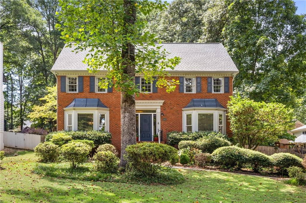 Welcome to this bright and light-filled brick home! Beautiful picture windows flood the home office and formal dining room with light along with the sunroom on the back of the home. Large family room with cozy fireplace is adjacent to the updated kitchen with stainless steel appliances, quartz counters and eat in breakfast area. Hardwoods run throughout the main level. Upstairs you'll find an oversized master suite with custom built-ins in closet and double vanity. Three spare and spacious bedrooms with ample closet storage share the hall bath. Finished basement is the perfect utility space for your music room, home gym, teen hang out or whatever suits your needs. Many updates include a NEWER roof, ALL baths updated, NEWER carpet, refinished hardwoods, interior paint and more. Large wooded backyard is private, fully fenced with a deck, stone patio, and fire pit area. Located in sought after Simpson Elem district, close to Wesleyan, Cornerstone and Perimeter Schools. Tons of shopping and restaurants at The Forum and Town Center plus Simpsonwood Park and Jones Bridge Park are just around the corner. Don't miss out on this great home!