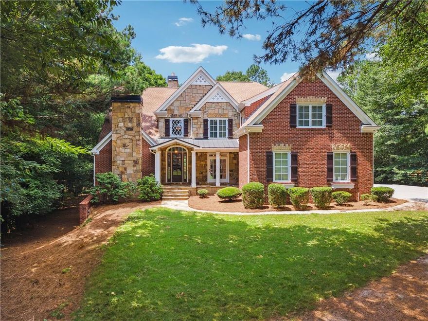 Nestled within the beautiful gated community of Blackberry Ridge, this expansive 2-acre estate home offers a seamless blend of luxury, privacy, and convenience. Located in Cherokee County with the benefit of lower taxes and zoned for the highly desirable Creekview High School, this residence showcases timeless finishes and a thoughtfully designed, spacious layout that epitomizes refined living.

As you approach, you'll be captivated by its stately four-sided brick and stone construction, highlighted by a charming stone front porch and a spacious private yard. Inside, the main level exudes elegance and functionality, featuring solid mahogany wood floors that add warmth and sophistication. The living room, with its soaring vaulted ceilings and a striking stone fireplace with a gas starter, creates an inviting atmosphere. Adjacent to this space, the gourmet kitchen is a true culinary haven, boasting granite countertops, a gas range, a large walk-in pantry, and a convenient butler’s pantry. Overlooking the spacious keeping room—complete with a cozy stone gas fireplace—this kitchen is designed for both everyday living and effortless entertaining.

The primary suite on the main level serves as a luxurious retreat, featuring a sitting room with a stone fireplace and vaulted ceilings that enhance the home’s distinctive character. Past dual walk-in closets, the spa-like primary bath impresses with a Jacuzzi tub, an oversized dual-head shower, and a coffered ceiling that adds a touch of grandeur. An additional ensuite guest bedroom on the main level provides comfort and privacy, making it ideal for in-laws, visitors, or a teen suite.

The upper level offers exceptional flexibility, featuring three ensuite bedrooms, a large fireside office/study, and a bonus room—perfect for use as a playroom, home office, or an optional sixth bedroom.

Designed for entertaining, the home’s three-sided walk-out terrace level is finished to the same high standards as the main level. This space includes a full wet bar kitchen with bar seating, custom-made backlit counters, and a stone fireplace in the sitting room. The game room, pool table area, and theater room—complete with a raised ceiling and sound system—offer endless entertainment possibilities. A full bath with laundry and ample extra storage space complete this level.

Notable features of this remarkable home include a circulating hot water system, a cedar closet, encasement windows, five fireplaces, dual in-line water heaters, and laundry rooms on all three levels. The home is also equipped with a central vacuum system. The oversized three-car garage provides ample space for vehicles and equipment, with additional storage at the front. Two of the three HVAC units were replaced in 2021/2022 for added efficiency and comfort.

Beyond the home itself, the location is another significant highlight. Situated just five minutes from 7 Acre Barngrill, Publix, and Scottsdale Farms, the property offers easy access to daily conveniences and dining options. It is only 15 minutes from downtown Milton’s Crabapple district, known for its charming atmosphere and community events. For those seeking a vibrant city lifestyle with effortless commuting, downtown Alpharetta, Avalon, and GA-400 are just 20 minutes away, offering premier shopping, dining, and entertainment opportunities.