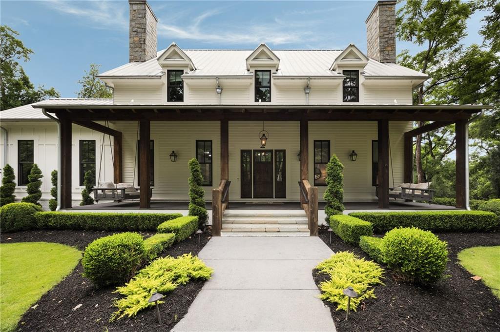 Welcome to your own private retreat in the heart of Milton. Set on 2.5 beautifully wooded acres behind a gated entry, this custom-built modern farmhouse by Steve Powell Homes combines timeless craftsmanship with the laid-back luxury of resort-style living. With a heated saltwater pool and spa, outdoor fireplace, and a backdrop of century-old oaks, this home offers the kind of privacy and setting that’s getting harder to find. From the moment you step onto the front porch, framed by cedar beams, gas lanterns and tongue-and-groove ceilings, you’ll feel the attention to detail that sets this home apart. Inside, 12-foot ceilings, reclaimed Pennsylvania barn wood floors, and natural light at every turn create a bright, welcoming feel. The fireside family room opens into a chef’s kitchen with quartzite countertops, a high-end appliance package, large center island, and walk-in pantry. Accordion-style doors lead to a vaulted, wood-lined lanai—an all-seasons space with a fireplace that flows effortlessly into the pool and patio area. The main-level primary suite is a true escape, featuring a spa-like bath with heated floors, a soaking tub, dual showerheads, and a custom walk-in closet with a packing island. Just off the closet, the laundry room is a workhorse—with space for two washers and two dryers, tons of cabinetry, a work island, built-in desk, and drop zone. Whether you’re managing a busy household or prepping for travel, this space makes life easier. Upstairs, you’ll find four generously sized en suite bedrooms, each with custom walk-in closets, plus a versatile bonus room and a cozy reading nook that’s perfect for quiet moments or homework hangouts. The finished terrace level adds even more to love—a full home theater, a flex space that works well as a gym or guest suite with its own full bath, and a fourth-car garage that easily doubles as a workshop or extra storage. Need more room to spread out? Above the main garage, an additional finished space offers endless potential—whether it’s an in-law suite, a game room, or your go-to spot for entertaining. From the Control4 smart home system and full-house generator to the winding drive, professional landscaping, and extra parking pads, no detail has been overlooked. Zoned for top-ranked Cambridge High and just minutes to Downtown Alpharetta, Avalon, and GA-400, this property offers the rare mix of privacy, convenience, and laid-back luxury that’s getting harder to find.