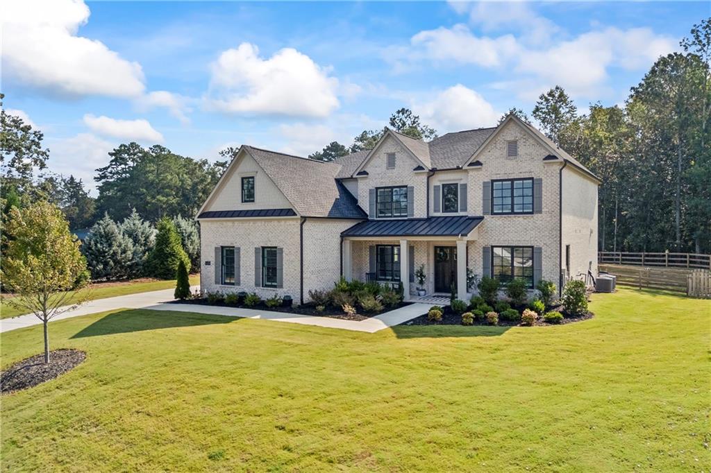 Nestled on a serene cul-de-sac lot within the exclusive Grand Reserve community, this striking Toll Brothers Payton model with a 3-car garage built in 2023 delivers refined comfort on a generous 1.05-acre setting. Step inside this nearly 4,500 sq ft home of meticulously designed living space, featuring a wide-open floor plan ideal for modern lifestyles. The gourmet kitchen stands as the heart of the home, equipped with Wolf appliances—including a 6-burner gas range and double ovens—an expansive walk-in pantry, and a smartly located mudroom for seamless daily routines. Adjoining the kitchen is an expansive, sun-lit family room, anchored by a grand fireplace flanked with built-ins and a dramatic stacking glass door system that invites effortless indoor-outdoor living and overlooks a private fenced backyard perfect for al fresco gatherings or a future pool. The main level also includes a versatile bedroom with ensuite bath, a dedicated home office, half bath and a formal dining room—ideal for entertaining or hosting family gatherings. Upstairs, a luxurious primary suite awaits with a spa-like bath and ample custom-designed closet space. Three additional well-appointed ensuite secondary bedrooms offer comfort and privacy. Community amenities enhance everyday living—enjoy access to a community clubhouse, swimming pool, tennis courts, and beautifully maintained sidewalks and street lighting. Located just minutes from downtown Roswell, Alpharetta, and Milton, this home delivers not only luxury but also lifestyle convenience, with easy access to premier dining, shopping, and entertainment options. Top-rated schools include Crabapple Crossing Elementary, Northwestern Middle, and Milton High School.
