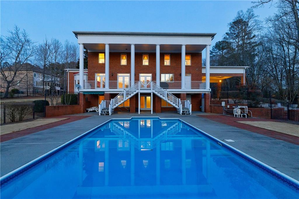 Discover one of the largest home sites close to downtown Milton with 3.82 acres and a stunning Southern Colonial style home. The open greenspace, gorgeous landscaping, fenced in large pool and natural pond are the perfect places to play, explore, have a home garden, have animals, gate or whatever your dreams desire! This beautiful home was meticulously crafted by its original owners, who handpicked the design from Colonial Homes Magazine, added a detached 2-car garage with living above, a finished basement, additional office on the main level and an inground saltwater pool. The natural views and pond with incredible wildlife and a large circular driveway make this home the full package! This Southern Colonial Greek Revival home is nestled off of Broadwell Road on a large private homesite in close proximity to downtown Milton/Crabapple where you will find incredible restaurants, events, schools, shopping and more. Step inside and be captivated by the grandeur of the curved Southern staircase that was custom built onsite and adds a touch of sophistication to the interior. Multiple wood burning fireplaces throughout the home create cozy and inviting spaces, perfect for relaxation and entertaining. The oversized rooms are very versatile. You will love the large Formal Dining Room with direct access to the Butler's Pantry that features a Copper sink, Cherry cabinetry, granite countertops and amazing storage. The open Kitchen is the heart of the home with Granite countertops, Stainless Steel 36" cooktop in the large island with downdraft, Stainless Steel double ovens, microwave, wine cooler, amazing Cherry cabinets and huge walk-in pantry. The Kitchen has a view to the breakfast area and the Family Room where you will enjoy a wet bar area, built-in bookcases, brick fireplace with gas logs and 3 sets of French doors that open to the covered deck. The covered deck is the perfect spot to enjoy the sunsets every night or have your next cookout as the gas line is already run to the perfect grilling spot. Tucked off the Family Room is an office or den that features a bay window, plantation shutters and a faux fireplace. The windows and privacy offer the perfect retreat for any lifestyle. There is a large parlor or living room with yet another brick fireplace, built-ins and cabinetry. As you head upstairs the room sizes are sure to amaze you! New carpet was just installed in June 2024 in the 4 bedrooms on the second floor. Two bedrooms share an oversize bathroom with double vanity, cabinet towers, separate large walk-in shower with updated tile and frameless shower door. Another secondary bedroom features an ensuite bath. The upstairs balcony off the hallway is the perfect touch with French doors. The owner's suite features French doors, a large double vanity, Jacuzzi bathtub, separate tile shower and walk-in closet. The finished basement provides additional living space with a large open space and full bath. The large full bathroom in the basement has an exterior entry for your pool guests and interior entrance for entertaining. Imagine hosting gatherings in the heart of your home, complete with a pool for summertime fun and a natural pond that enhances the picturesque beauty of the surroundings. For those who appreciate privacy and convenience, there is a detached garage with a large bonus room above. This additional finished living area is stubbed in for a full bath, kitchenette and laundry area. You will love the large workshop area off the 2-car detached garage to use for your newest woodworking project or great storage. Come indulge in the luxury of an iconic residence, where every detail has been carefully considered. Don't miss the opportunity to call this extraordinary property yours – a true masterpiece in the coveted Crabapple area. Your dream property with water views awaits!