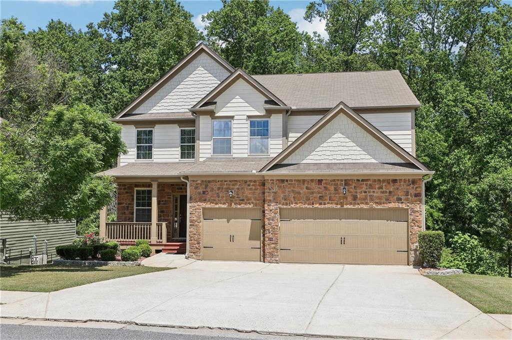Spacious & Bright Home in Sought-After Swim/Tennis Community! Welcome to this stunning home nestled in one of the area’s most desirable swim/tennis neighborhoods, offering bright open spaces, upscale finishes, and exceptional community amenities. From the inviting front porch to the beautifully manicured landscaping, this home exudes curb appeal and comfort. Step inside to a dramatic two-story foyer flanked by a formal living/flex space, perfect for a home office or sitting room. Rich hardwood floors flow throughout the main level, complementing the formal dining room with its elegant coffered ceiling and detailed chair railing. The heart of the home is the expansive open-concept family room, filled with natural light and centered around a striking stone fireplace. The adjacent chef’s kitchen is a dream—featuring a large island with seating, granite countertops, stylish tile backsplash, stainless steel appliances including a double oven, and a walk-in pantry. A main-level bedroom with a walk-in closet and full bath offers ideal guest/MIL accommodations. Upstairs, retreat to the oversized primary suite with tray ceiling, spa-like bath with dual granite vanities, soaking tub, glass-enclosed shower, and a large walk-in dressing closet. Two additional bedrooms share a Jack-and-Jill bath, while a third has its own private en-suite with hall access. A spacious loft/game room provides the perfect flex space for movie nights, gaming, or a secondary living area. Need even more room? The finished basement offers luxury vinyl plank flooring, multiple gathering areas ideal for fitness, entertaining, or additional bedrooms, plus a dedicated office with a closet, a media room, full bath, and an unfinished storage area. Additional highlights include a 3-car garage with 240V EV charging outlet, a Google Nest smart home system, and a smart garage door. Step outside to the oversized upper deck with serene wooded views—perfect for grilling and outdoor entertaining. Enjoy resort-style living with access to community parks, playgrounds, walking trails, tennis and basketball courts, volleyball, and a sparkling pool. Mortgage savings may be available for buyers of this listing !