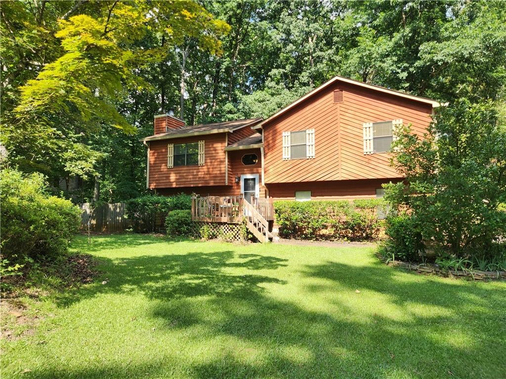 Split-level residence featuring wood siding and a covered front porch with wooden railings
