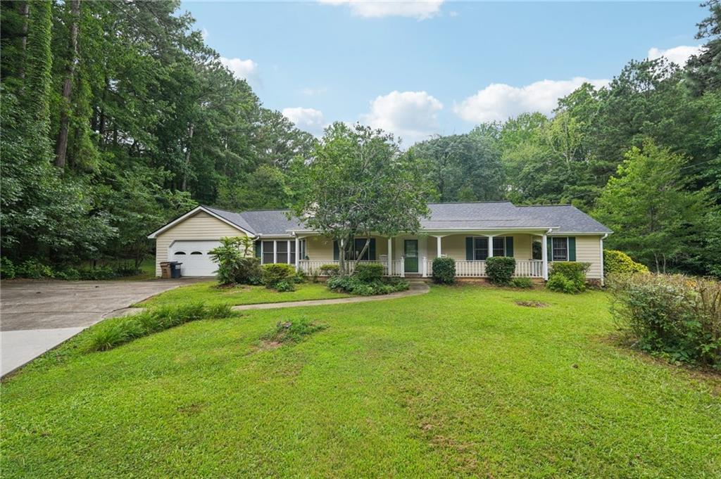 Welcome to this charming 3 bedroom, 2 bath one-level home, nestled on a peaceful two acre lot surrounded by mature trees. Enjoy the warmth of wooden floors, a spacious island kitchen with granite countertops, and a bright sunroom with soaring ceilings and plenty of natural light. New roof in June 2025. Step out onto the back deck and take in the serenity, or take advantage of the extra storage and attached 2-car garage. Great location, comfort, space, and charm—all in one beautiful package!