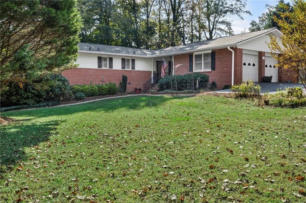 WELCOME to ONE LEVEL LIVING with a FULL FINISHED TERRACE LEVEL on nearly 1 ACRE with NO HOA!!! This incredibly SPACIOUS 3BR/2BA home features a REMODELED KITCHEN with WOOD CABINETS, QUARTZ COUNTERS, STAINLESS APPLIANCES, and an incredible amount of STORAGE. The OVERSIZED FAMILY ROOM centers around a cozy fireplace and built-in shelving and opens to a MASSIVE HEATED & COOLED SUNROOM with TONGUE & GROOVE ceilings—an ideal spot for relaxing or entertaining year-round. The primary suite includes two closets and a private bath with walk-in shower, while two spacious secondary bedrooms share an updated hall bath. The finished basement adds approximately 1,400 SF of flexible space, including an additional fireside family room, office area, full bath, and plenty of storage. Enjoy the outdoors and sounds of nature on three decks--all 3 were just painted and they are ready for your enjoyment.
The OVERSIZED DRIVEWAY IS PERFECT FOR YOUR TOYS & there is room for RV PARKING. Just MINUTES from CUMMING CITY CENTER, excellent schools, shopping, dining, and parks, this home offers the lifestyle you’ve been looking for; WELCOME HOME!