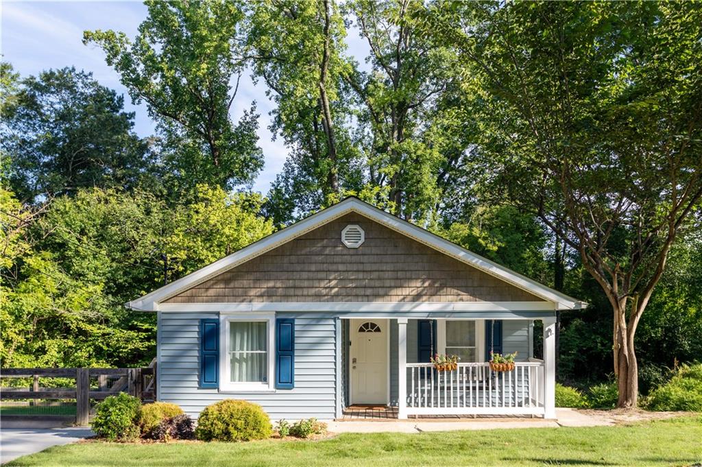 Tucked away at the end of a quiet dead-end street, this charming 1920s blue craftsman in Riverside is full of character and thoughtful updates—including a brand new roof, spacious primary suite addition with soaring, vaulted ceilings, a large bathroom, and a walk-in closet that creates the perfect private retreat. The home sits on an oversized, flat 0.4+ acre lot with a fully fenced & level side yard—perfect for pups—and a large backyard with endless potential. Enjoy three inviting porches, including a front porch with a sweet swing perfect for morning coffee or relaxing evenings. Inside, you’ll find original hardwood floors, a brick fireplace, and an open-concept kitchen with exposed shelving that flows seamlessly into the living room. The fantastic, light-filled laundry room makes everyday routines more enjoyable. A huge unfinished basement offers excellent storage. Located within walking distance from beloved Bellwood Coffee, Frazie's Market, historic Whittier Mill Park, and the Chattahoochee River, you'll love the area, the welcoming Riverside community, and the easy access to major highways. Not to mention it's just a quick drive to Buckhead or Truist Park and the Battery! With timeless charm, great neighbors, and unbeatable outdoor space, this home is a true hidden gem.