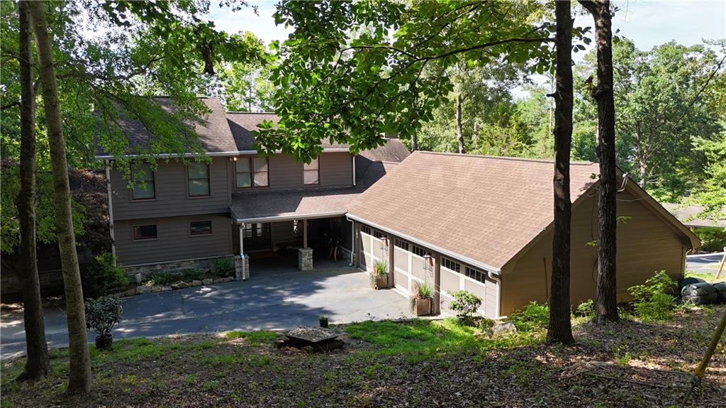 Experience the ultimate Lake Lanier lifestyle in this spacious and thoughtfully designed and fully renovated home, tucked away in a private, wooded setting just steps from your own 24x24 single-slip party dock with room to upgrade to a Corp approved 32x32 slip. With lake views and direct water access, you can go from boat to back door in under a minute—making this home a dream for entertaining, relaxing, or short-term rental potential. Enjoy worry free living with recent upgrades like brand-new roof, tankless hot water heater, and white oak site finished flooring.
The main level features a luxurious primary suite, soaring vaulted ceilings in the living room, a dedicated office, and a chef’s kitchen that flows effortlessly into a keeping room and an oversized dining area that seats up to 20 guests. The kitchen boasts a 48" GE Monogram range, Electrolux oversized side by side refridgerator and freezer, as well as a walk-in pantry and additional cabinet pantry storage with pull out drawers. Also on the main level: a well-placed laundry room for convenience and functionality. A built-in Sonos speaker system runs throughout the home, delivering rich sound for entertaining or enjoying your favorite playlist in every room.
Upstairs offers two additional bedrooms and a full bathroom, while the fully finished basement expands your living space with two more bedrooms (one currently being used as a gym), two full baths, a spacious media room/living area is perfect for game day or cozy movie nights and still leaves room for ping pong, card table or your game of choice.
Step outside to enjoy the peaceful North Lake Lanier surroundings from your covered patio—ideal for morning coffee or evening cocktails. Rinse off after a day on the lake in the outdoor shower, and take advantage of the oversized 3-car garage for all your lake toys, vehicles, and storage needs. The turf backyard is the perfect set up for endless games of cornhole. Whether you're searching for a full-time residence, weekend getaway, or short-term rental investment opportunity, this property offers space for everyone and every occasion. Conveniently located just off GA400 and minutes from the Dawsonville Outlets, Publix, Kroger, and more—yet surrounded by nature and serenity.