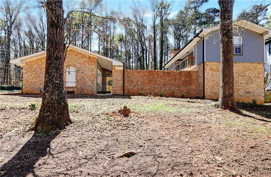 View of home's exterior featuring brick siding and a gate
