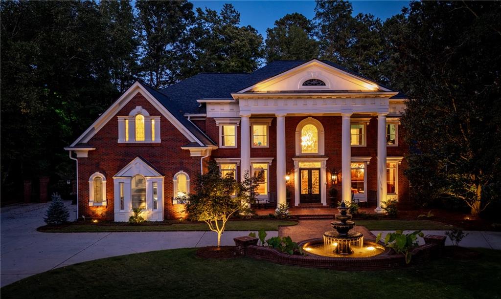 Welcome to your private sanctuary in the heart of Country Club of the South, located in highly desirable Johns Creek! This traditional Georgian estate, beautifully positioned on 1.4 luxuriant acres, offers elegance & tranquility at every turn. The circular drive w/ illuminated fountain sets the tone for the grandeur of this exceptional property graced with the backdrop of the award winning Jack Nicklaus golf course. The home’s spectacular backyard oasis promises to captivate and impress with its heated saltwater pool & spa, soothing water feature & sweeping pool deck for lounging in the sun. The certified backyard by Birds of Georgia is a wildlife habitat set amidst a breathtaking landscaped paradise that includes a plethora of flowering greenery, unique trees & charming brick and stone paths. The grand entry welcomes you into the foyer with soaring ceilings that flood the home with natural light. A wood-paneled library w/ grass cloth wall covering & fireplace offers a sophisticated space to work or unwind. The two-story great room, with its intricate inlaid hardwood floor and exquisite barrel ceiling with extensive millwork and fireplace, is a showstopper for entertaining.The chef’s kitchen, with white cabinetry, granite countertops, 6-burner Wolf stove, double ovens, island & spacious pantry, flows effortlessly into the breakfast room and fireside keeping room while offering picturesque views of the serene backyard & pool. The sumptuous primary suite on the main offers tranquil natural views and is a spa-like haven w/dual custom closets and heated floors. Upstairs, a second master suite features new hardwood floors, double oversized closets, a cozy fireside sitting area, and spa bath with tile flooring and custom cabinetry. Two additional spacious secondary en-suite bedrooms offer privacy & comfort for family and visitors. The impressive terrace level boasts new travertine floors, a bar/kitchen area with dishwasher, refrigerator and wine cabinet all overlooking an inviting sitting area w/fireplace and direct access to the outdoor living. A private media room, mirrored exercise room w/ full bath, two additional en-suite bedrooms and extensive storage areas complete this level. A charming brick breezeway draws you outside to the meticulously designed outdoor living spaces that surround the pool, offering endless opportunities for relaxation and entertainment. Enjoy the sweeping custom paver deck, gas fire pit & outdoor kitchen, all accented with soft lighting for enchanting evenings under the stars. Every detail of this estate reflects impeccable craftsmanship and striking architectural features. With endless opportunities for enjoying exceptionally designed indoor & outdoor living spaces, this home is truly a one-of-a-kind and ready for worry free move it! The security, amenities & access to top rated schools, make Country Club of the South the place to live! Come witness the unparalleled lifestyle offered by this breathtaking estate!