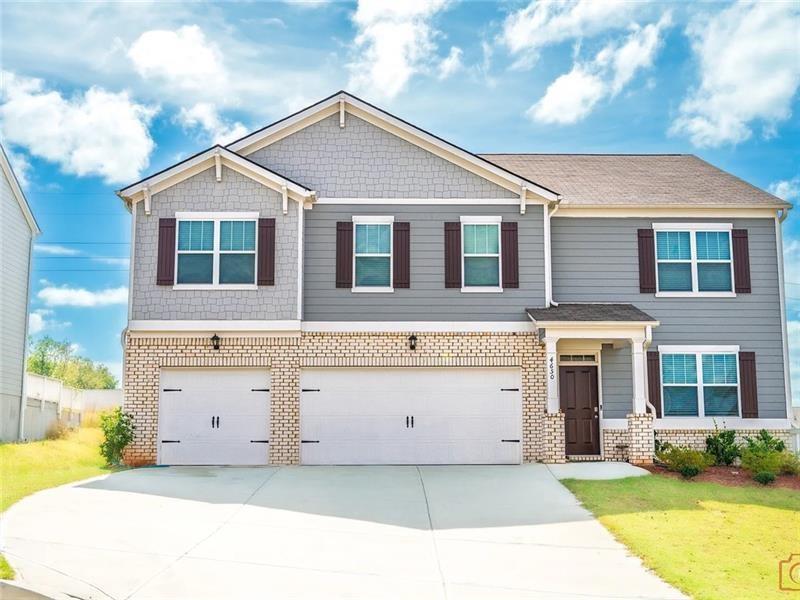 Craftsman inspired home featuring brick siding, concrete driveway, an attached garage, and a front lawn