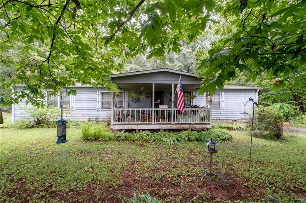 WELCOME to your next HOME with plenty of room to GROW, on over 2.5 acres and a HUGE backyard in the up-and-coming town of Dallas, and the BEST schools and LOTS of good restaurants in Paulding County, Georgia. This property has a country-living kind of feel, with a large and level back yard, a huge workshop & storage barn with an upstairs loft, and there is beautiful stone fire pit in the backyard too, yet it's less than an hour from downtown Atlanta! This spacious 3 bedroom, 2 bath home has been well loved and is ready for a new owner to make it their own. This home has an expansive and open floorplan with a large and almost circular kitchen that would make cooking a breeze. The bedrooms and bathrooms are oversized and yet cozy. There is so much potential on this wooded and level lot, with it's beautiful and lush established landscaping in place already, and plenty of room to do what you please, without any HOA or deed restrictions, either. It could be a great spot for an additional dwelling, a family compound or even a new manufactured home as the infrastructure and utilities are already in place, and yet it is peaceful and convenient too! Call or text today for an easy showing!