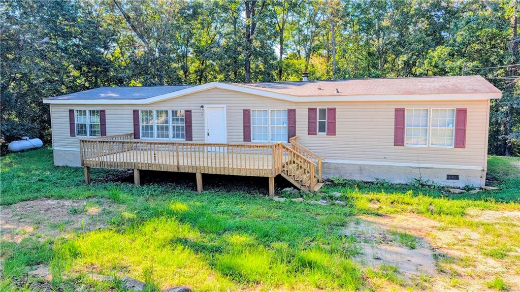 Four bedroom ranch on over one acre in Dahlonega! Spacious floor plan with split bedroom layout. Additional den with pretty black painted stone wood burning fireplace. Laminate flooring throughout. Master bath has a soaking tub and walk in closet. Laundry closet / mudroom conveniently off the kitchen. House is on a permanent foundation and is being sold as is. Minutes from downtown Dahlonega, shops, restaurants and UNG. Property has been a long time rental. Rent rolls available on request.