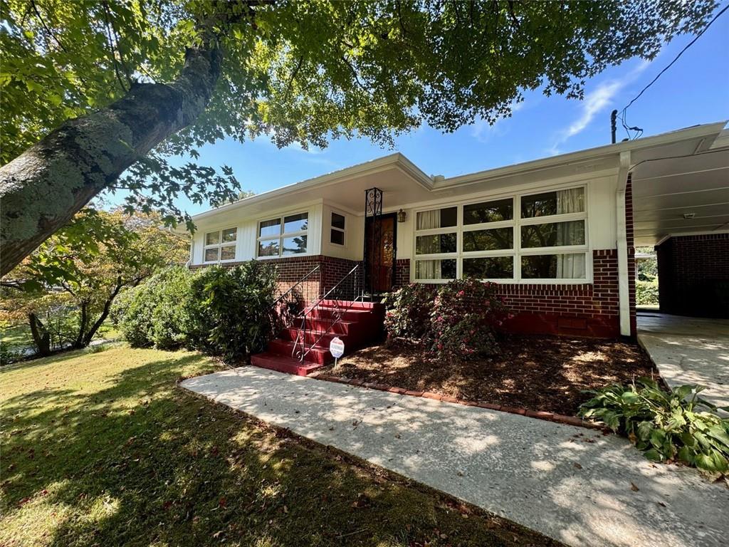 Have you been looking for a move in ready 3/2 north of Atlanta and inside the Perimeter? You may have just found it! This well maintained all brick 1950s ranch sits on a large corner lot with established, manicured landscaping. The positioning of your next home makes you feel as if you are inside a treehouse when you sit in the living room and overlook your yard with large oak trees that provide privacy and shade. Natural light fills the home. The home has maintained the vintage charm with original hardwoods, original tiles, heart of pine paneling and whole house fan. An addition to this home added a large family room with wood burning fireplace and deck.Your primary bedroom features an ensuite bath. The laundry room is located just off of the kitchen in the carport. An outbuilding provides additional storage and the backyard is fenced in. Your next home is nestled in a quiet, established Doraville neighborhood with easy access to 85, 285, Buford Hwy and shopping. Easy walking distance to Brook Park with tennis courts and playground; also easy walking distance to public transportation. Your next home just awaits your special touches. Schedule your easy viewing appointment today!