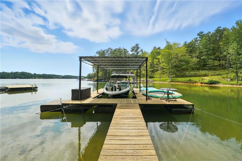 Adorable Rare Lake Allatoona Home with Private Dock – 1.892 Acres in Gated Community. Welcome to your perfect lake escape! Nestled on 1.7 flat and wonderfully usable acres in a private, gated community on Lake Allatoona, this charming 2-bedroom, 1-bath home offers comfort, privacy, and endless opportunities for lakefront living. Property Highlights: Private Dock with newer wood decking – just a short walk or golf cart ride away! Dock includes an 8x20 slip that easily accommodates up to a 24-ft boat. Spacious open layout with a large entertaining area and expansive deck. Private fenced yard for pets, kids, or quiet relaxation. Pre-Engineered Metal Building - Red Iron Building (30x40) with 12-ft doors & garage door opener – perfect for vehicles, a workshop, or lake toys. Additional storage building on separate meters + RV storage. Spray foam insulation keeps the home efficient & easy to heat/cool. Flexible layout allows for easy add-ons of extra bedrooms/bathrooms if desired. Well available on property (not currently in use). Community has recently paved roads, gated security, and a peaceful, private setting. Whether you’re looking for a primary residence or a lake getaway, this property has no restrictions and offers the perfect blend of comfort, storage, and lake access. Don’t miss your chance to enjoy life on Lake Allatoona with your own private dock and plenty of space to grow! Call today to schedule a showing and make this adorable lake home yours!