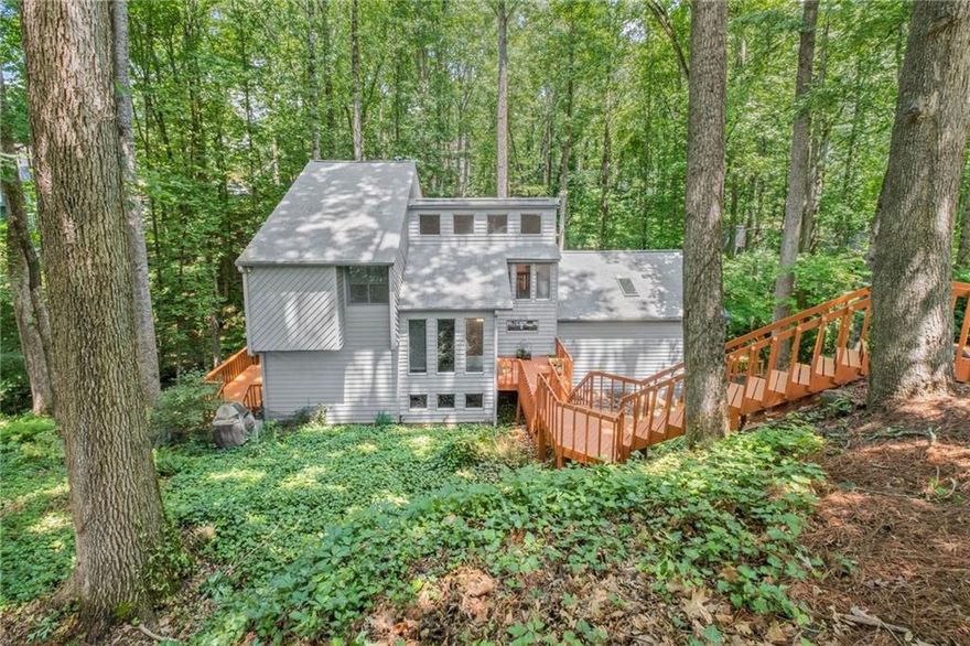 Escape the hustle and bustle of East Cobb nestled in your own private wooded retreat located at the end of cul de sac. This 4 bedroom 3.5 bath home located in East Cobb coveted trifecta of schools is now available for immediate occupancy. Spacious Eat in Kitchen has been renovated with up to date style and large island topped with all stone counters, deep sink, modern faucet, stainless steel appliances and range hood all top hardwood flooring. Incredible great room with vaulted ceilings floor to ceiling fireplace and abundant windows and skylights contribute to the open and airy contemporary feel. Hard to find primary ensuite on main level includes fireplace, hard woods and plenty of room for separate seating area surrounding the fireplace. Primary bath has a complete renovation with deep soaking tub separate tiled shower ad dual vanities. Head upstairs where you find 2 generous sized bedrooms connected by shared bath in addition to a versatile windowed loft area on the opposite end of the 2nd floor. The terrace level continues with generous rooms and has a great family room with a wet bar too.Loads of space for all the your recreation fun. Additional 4th bedroom with adjacent full bath provides multiple options for use such as a home office, gym or guest room. Mutiple access across 2 levels of the home to wrap around decking provides wonderful views of your large private lot and also provides plenty of space for entertaining. Newer roof, HVAC and water heater Home has just been refreshed with paint and newly installed carpet. Driveway Retaining wall replaced just this month Garage has been outfitted for EV charging  Make your move and enjoy the full amenities the community provides for the whole family!