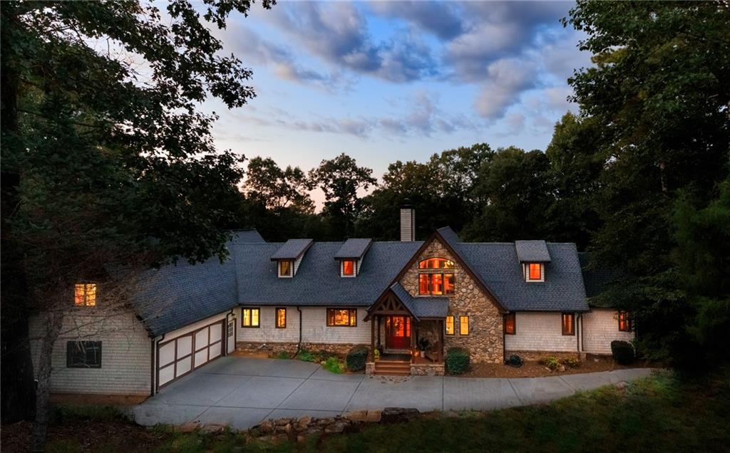 Welcome to this GORGEOUS TIMBER FRAME ESTATE! Nestled on over 2 PRIVATE, WOODED ACRES with
an option to purchase an ADDITIONAL 2+ acre parcel to build a second home, barn, garage or just for
your privacy and peace-of-mind. Enjoy direct trail access to the ETOWAH RIVER and beautiful LONG-
RANGE VIEWS of the NORTH GEORGIA MOUNTAINS. This EXQUISITE, CUSTOM home provides a
peaceful, country mountain setting while being conveniently located minutes from groceries,
restaurants, an easy commute, and more!! Custom Designed by MILL CREEK POST & BEAM Co. This
cedar and stone home features SOARING VAULTED CEILINGS, WIDE-PLANK PINE FLOORS, and MASSIVE
EXPOSED BEAMS. The expansive great room features a TWO-SIDED STONE FIREPLACE and GORGEOUS
WALL-TO-WALL WINDOWS which showcase views of the river valley and North Georgia Mountains
beyond. Fine finishes include TONGUE AND GROOVE CEILINGS, SOLID ALDER DOORS, CUSTOM
IRONWORK and so much more. Designed for energy efficiency and built to last centuries, the home is
enclosed in STRUCTURAL INSULATED PANELS, which provide high R-Values and LOW energy bills. The
cost to build this home today is well over 2M. The heart of the home is the GOURMET KITCHEN, with an
8-foot island and tons of cabinet space. Designed with the family chef in mind, high-end MONOGRAM
appliances, GRANITE countertops, a SIX-BURNER cooktop, WARMING DRAWER, ADVANTIUM SPEED
COOK OVEN, and GORGEOUS WALK-IN PANTRY will make cooking a joy. The country kitchen’s dining
space is centered around the FIREPLACE, and offers the PERFECT SPACE FOR ENTERTAINING with a fire
and a view! Designed for ranch living, the MAIN-LEVEL PRIMARY SUITE features a PRIVATE COVERED
DECK with indoor/outdoor living sliding doors, a SPA-INSPIRED BATHROOM, and a CUSTOM WALK-IN
CLOSET. Two additional main-floor bedrooms share a JACK-AND-JILL bath. A half bath and a LARGE
LAUNDRY ROOM with BUILT-INS are also on the main floor. A LOFT overlooking the GREAT ROOM
would be a wonderful home office or private reading space. Upstairs is a second Master Suite with a
LUXURY BATH and WALK-IN CLOSET. An EXPANSIVE BONUS ROOM offers FLEXIBILITY as a FIFTH
BEDROOM or BONUS ENTERTAINMENT SPACE. The nearly 3,000 SQ FT UNFINISHED BASEMENT is
already INSULATED and FRAMED with a FIREPLACE INSERT, offering ENDLESS POTENTIAL for
CUSTOMIZATION. An awesome MAN-CAVE space with double-door access will give you a great place for
home projects. Outdoors, enjoy 900 SQUARE FEET OF DECKING, a FENCED PADDOCK for dogs or ponies,
and SERENE NATURAL SURROUNDINGS. Additional features include an OVERSIZED 750+ SQ FT GARAGE,
COPPER GUTTERS, TANKLESS WATER HEATER, and PELLA ARCHITECTURAL, DOUBLE-PANE CASEMENT
windows with wide overhangs to enjoy a nice breeze even when it rains! Zoned for TOP-RATED
FORSYTH COUNTY SCHOOLS, and eligible for the FORSYTH COUNTY SENIOR TAX EXEMPTION, this home
perfectly combines PRIVACY, the TRANQUILITY OF NATURE and LUXURIOUS LIVING close to MODERN
CONVENIENCES. This is your OPPORTUNITY to OWN a TRUE NORTH GEORGIA MASTERPIECE that is
PRICED WELL BELOW APPRAISED VALUE! This caliber of home doesn't come on the market very often!
SCHEDULE YOUR PRIVATE SHOWING TODAY!!!