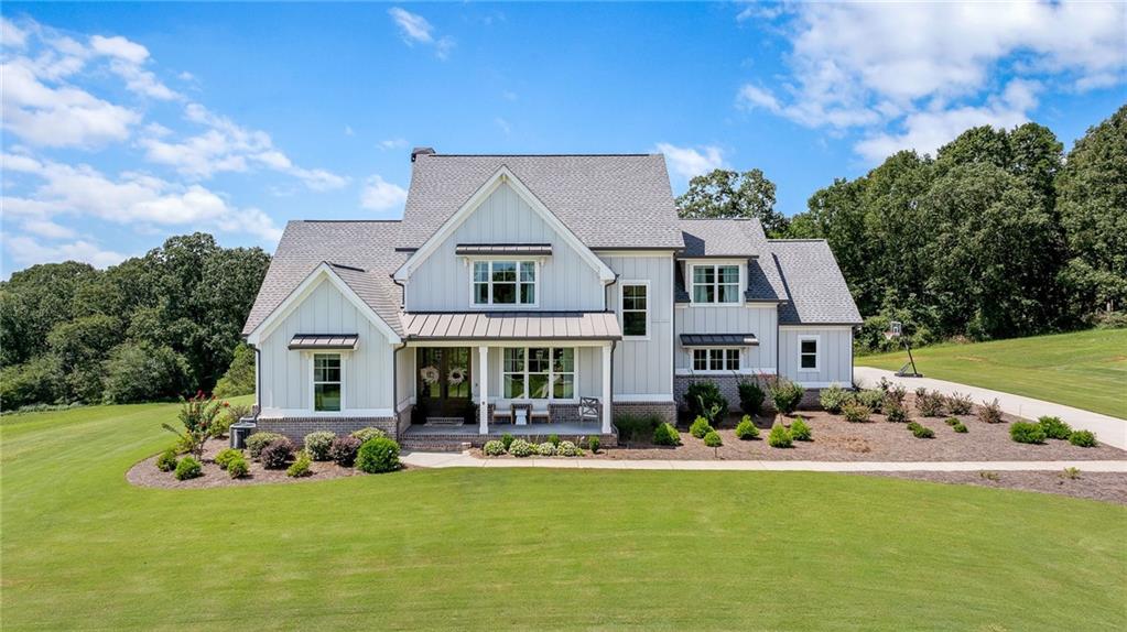 Welcome to this stunning home perfectly situated on 5 private acres within a gated community, offering breathtaking lake views and ultimate privacy. The large covered front porch with stately columns sets the tone for the charm and elegance found throughout.
The private owner’s suite is conveniently located on the main level, featuring a spa-like bathroom with double vanities, walk-in shower, soaking tub, and private water closet. The gourmet kitchen is designed for entertaining, complete with a spacious island topped with quartz countertops, stainless steel appliances including a gas cooktop, wall oven, microwave, dishwasher, and built-in beverage storage. A walk-in pantry provides ample space to keep everything organized.
Enjoy seamless open-concept living with views from the kitchen into the family room, where a beautiful fireplace, custom bookshelves, and access to the covered back patio create the perfect gathering space. Upstairs, you’ll find three additional bedrooms plus a finished bonus/bedroom with a full bath—ideal for guests or flex space.
This home showcases a high-end trim package and gleaming hardwood floors in the foyer, office, family room, kitchen, and dining area. There is also an option to purchase an additional 5+ acres directly adjacent to the property for those seeking even more space.