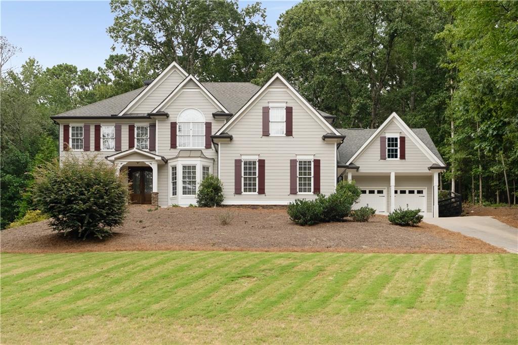 Stunning Alpharetta Home in the Sought-After Creekview High School District! Located in desirable Cherokee County, this rare find offers a seamless walk-out from the main level to a private backyard oasis. Situated on nearly one acre (.92 acres), the property features a saltwater pool, finished terrace level with full in-law suite, and a 4-car garage with exterior access to an unfinished bonus room above. Inside, beautiful hardwood floors flow throughout the main level. The spacious family room boasts floor-to-ceiling windows and a fireplace overlooking the pool and backyard. The main level also includes a guest bedroom with a full bath, a formal dining room with Butlers Pantry and a versatile living room/office. The chef’s kitchen is designed with stone countertops, stainless steel appliances, a gas cooktop, walk-in pantry, and ample cabinetry. Upstairs, the expansive primary suite serves as a true retreat with a spa-like bath and a generous walk-in closet. The finished terrace level is ideal for entertaining or extended guests, offering a living area, full kitchen, and additional bedroom with private full bath. Combining style, function, and outdoor living, this exceptional home truly has it all, space, luxury, and a backyard built for relaxation and entertaining.