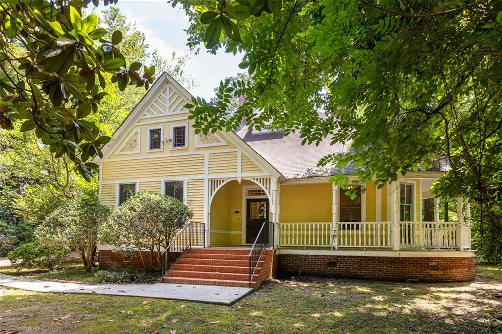 Charming Turn-of-the-Century Victorian Cottage in Downtown Decatur. A rare opportunity to own a piece of history in prime South Candler Street location. Step into timeless elegance with this captivating Victorian cottage that blends historic charm with endless potential. This turn-of-the-century gem sits on an exceptionally large, deep lot offering both privacy and possibilities. The moment you enter, you'll be enchanted by the soaring ceilings, original windows, wide center hall, original heart pine floors and exquisite period trim work that showcases the craftsmanship of a bygone era. Six original fireplaces serve as stunning focal points throughout the home. The home has three generously sized bedrooms, including a large primary suite with ample storage, and a large laundry room. The wraparound front porch invites leisurely afternoons, while the back porch extends your living space into the large, fenced yard. A deep front yard creates a private oasis, buffering you from the street while maintaining the neighborhood's walkable charm. The expansive lot presents exceptional opportunities - ample space for a future pool, potential for an ADU (Accessory Dwelling Unit), or room to create your own private estate in the heart of Decatur. This home is positioned to have the best of both worlds: enjoy the tranquil, tree-lined setting of South Candler Street while being just steps away from vibrant downtown Decatur. Walk to acclaimed restaurants, boutique shopping, farmers markets, and community events, all while returning home to your historic sanctuary. This rare combination of historic charm, generous lot size, and premium location creates an exceptional opportunity. Whether you envision restoring this Victorian beauty to its original grandeur or thoughtfully updating it for modern living, the bones are spectacular, and the potential is limitless. Don't miss this chance to own a piece of Decatur's architectural heritage on one of the most desirable streets in the city.