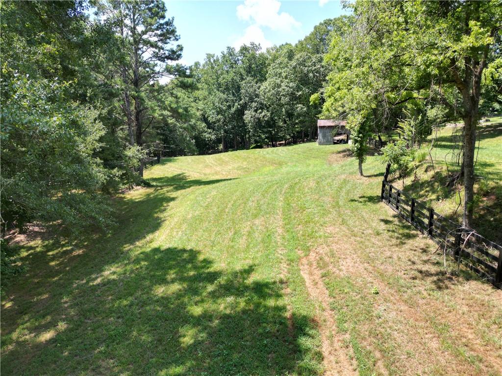 Incredible opportunity to own property in Milton with the space to build an exquisite estate; whether that be equestrian, recreational or a gentleman's farm. This property zoned AG is at the end of one of Milton's few and coveted gravel county roads, where horse farms dominate. Rolling pastures and open hardwoods provide multiple homesites for those that want out in the open or in the shade. A creek on the property line gives you access to year around water. If you are looking for a property on a quiet street away from the sounds of traffic, then this is the property for you. If you want additional acreage, more is available that is adjacent to this. Less than 5 minutes to the Birmingham Publix and 7 Acre bar and restaurant and 20 minutes to downtown Alpharetta, provide close and easy luxury shopping while feeling rural.