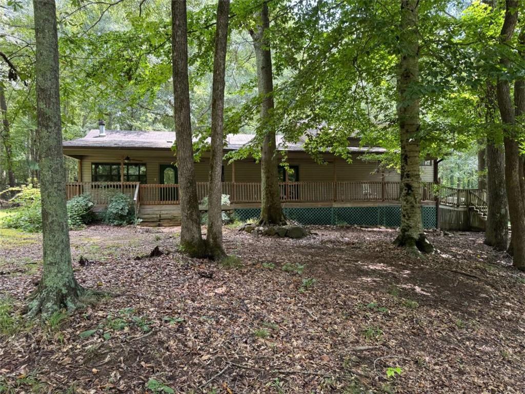 Very private, wooded, 21+ acres plus 3 bedroom, 2 bath ranch home. Land partially cleared. Barn. Land is suitable for farming and hunting. Creek runs through property. Home features, both family room and den. Hugh porch spans the entire front of the home. Public water, but 2 wells on the property. 2 car garage.