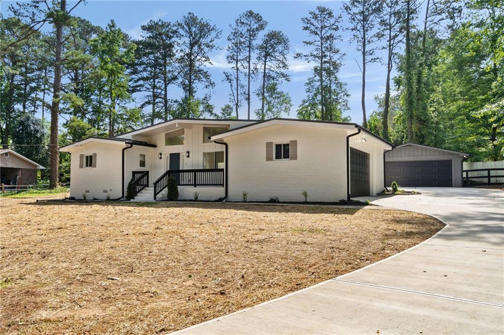 Don't miss a rare opportunity to own such a unique home and property located just minutes from the heart of East Cobb with interstate access. This fully renovated home features contemporary design with modern finishes. Located at the end of the street, this home will afford you all the privacy you have been looking for. You will be minutes from everything, but you will feel like you are miles away. As you approach, you will notice that you are surrounded by large lots with mature trees. As you pull in the drive, you will be excited to see not only the side entry garage, but an additional separate two-car garage that can be the wood or auto shop you always wanted. Step inside and find natural toned floors, black and gold metal features, and tall ceilings. The newly renovated kitchen boasts white modern cabinetry, quarts countertops, a subway tile splash, and stainless appliances. In addition to the three bedrooms, you will find two newly renovated bathrooms. Custom vanities, quartz tops, and custom tile surrounds really set this home part from the competition. Step out onto the brand new patio in the back to find a large, cleared lot that has been fenced in with a split rail fence, finished off to keep the pets in. Perfectly located right off Roswell Rd, this home gives you East Cobb status and instant access to the interstate for that quick commute to the city.