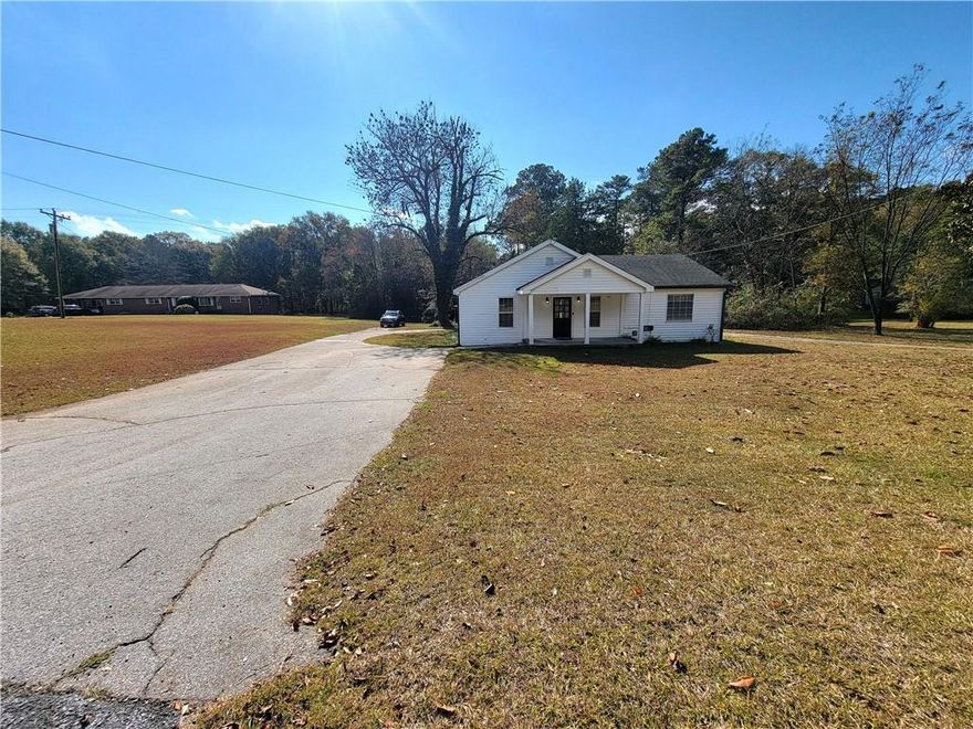 Welcome to this beautifully updated 4-bedroom, 3-bath ranch home ON 2 Acres! Wrap-around driveway providing ample parking space. Covered rocking chair front porch setting with street views. Step inside to an inviting open floor plan that begins with a cozy living area just off the foyer. The open eat-in kitchen is the heart of the home, featuring a large island, stainless steel appliances, and a clear view into the family room—perfect for entertaining or everyday living. The spacious primary suite includes a walk-in closet and a private full bath. Secondary bedrooms are generously sized and offer ample closet space, providing comfort for family or guests. Laundry room off the family room featuring a sink and stackable washer/dryer. Covered rear porch with workshop outbuilding in need of some TLC. Additional storage shed and a few carport areas. Located in a quiet neighborhood with easy access to shopping, dining, and major highways, this home offers the perfect blend of charm and functionality.