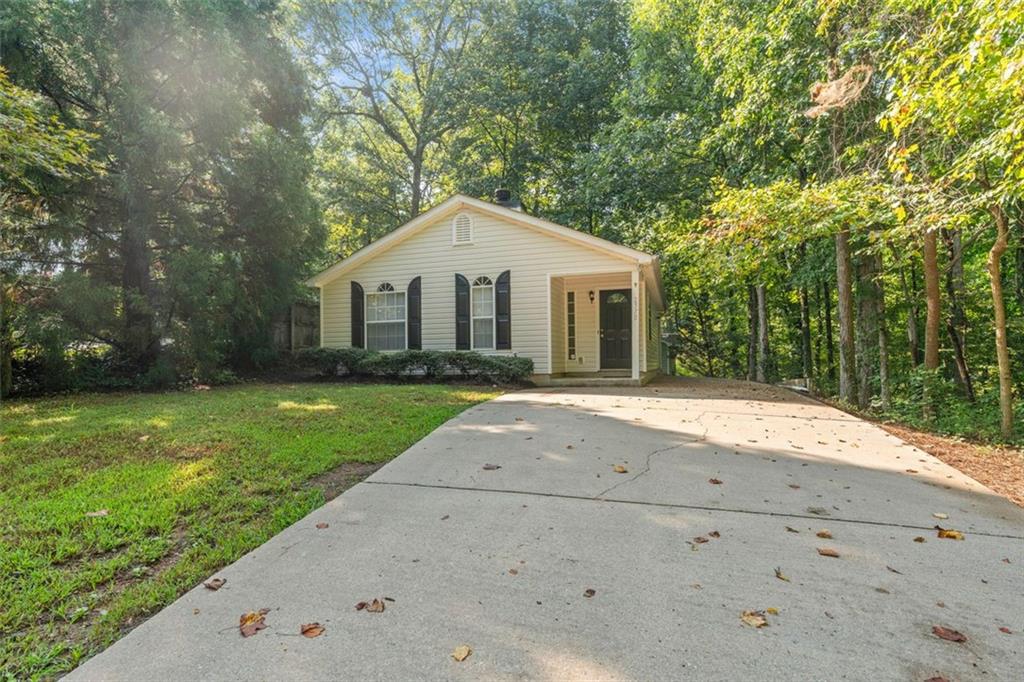 Discover the perfect little place close to the lake! This charming 2-bedroom, 2-bath home is move-in ready and full of recent upgrades, nestled on a large wooded corner lot just minutes from Lake Lanier. Whether you're looking for a primary residence, a weekend retreat, or an investment opportunity, this property offers comfort and convenience in one affordable package. Step inside to find a freshly painted interior and an open, welcoming layout. The brand new luxury vinyl plank (LVP) flooring runs throughout the home, offering a clean, modern look that's also durable and easy to maintain. The living room features a wood-burning fireplace and the kitchen has been updated with new appliances and new countertops, giving the space a fresh, functional feel. Both bedrooms are well-sized and one features an ensuite bathroom. Peaceful, wooded lot, offers privacy and a small space to garden. The location is a true highlight—just minutes to Lake Lanier, with easy access to boat ramps, parks, and water activities. You'll also appreciate the quick commute via GA-400, and the close proximity to the Cumming City Center, which offers a vibrant mix of shopping, restaurants, and entertainment. From local dining spots to boutique stores and a seasonal amphitheatre with free live music from spring to fall, there's always something to enjoy nearby. This home combines updated interiors, a spacious outdoor setting, and an unbeatable location. Whether you're seeking a low-maintenance lifestyle, a weekend escape, or a cozy place to call home, this one has it all. Bring your boat, bring your toys, and make this Lake Lanier gem yours today!