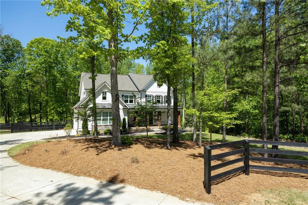 Fabulously appointed Farm House Estate located on over 2 acres  with amazing outdoor space.  Located on a prime cul-de-sac lot, inside an intimate gated community, this home has something for everyone.  Features a large fenced yard, 3 car garage, and incredible backyard area with beautiful wooded views and new pebble tech salt water pool/spa. The main level includes a bedroom with private bath, elegant Dining Room, an office/seating area,  living area with fireplace plus expansive kitchen with large quartz island, breakfast bar, walk-in pantry, and stainless steel kitchen aid appliances including a 6 burner cook top. Kitchen and living room allows views of the pool and backyard.  Back deck is perfect for grilling with stairs to your own private pool oasis.  Resort style pool/spa with travertine decking,  water features & sun ledge, and built in natural stone fire pit.    Upper level has master suite, with expansive master bath that has a double entry shower with 5 heads and seating area. Large soaking tub. Extra large walk in closet. Also, Guest Suite with private full bathroom.  Two other bedrooms share a jack and Jill bath. All bedrooms have loads of closet space.  Almost new home is move-in ready. Pool area is spectacular. Great Schools. Full unfinished basement, stubbed for full bath. Great Alpharetta location close to several golf courses and equestrian facilities, with lower Cherokee taxes. Wonderfully private setting, a true must see!