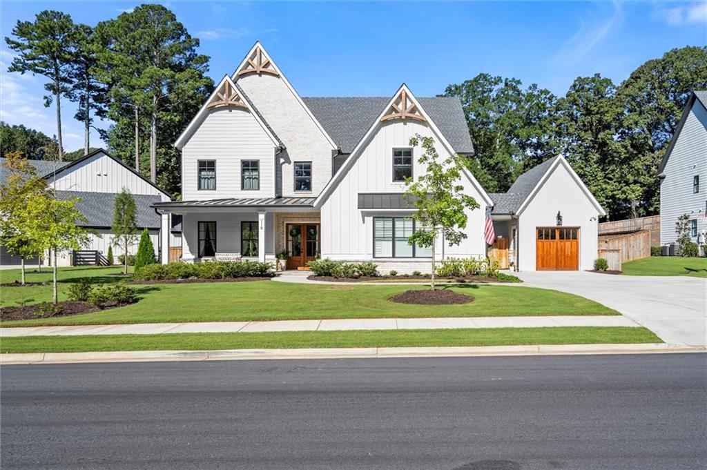 Located in the desirable Magnolia Reserve community, this stunning Heritage plan by Epic Homes Georgia offers the perfect blend of elegance and convenience. Situated in a quiet enclave of just 14 homes, you’ll enjoy the benefit of Cherokee County taxes, while being just minutes from Downtown Crabapple, Downtown Roswell, and Downtown Woodstock, with easy access to Highway 92.
The front porch leads into the 2-story foyer, which flows into the grand family room with soaring ceilings. The open concept design includes a slider door that opens to a covered screened in patio, overlooking a level backyard with future pool possibilities.
The formal dining room connects to the spacious kitchen, which features quartz countertops, floor-to-ceiling cabinetry, a large island for entertaining, and a butler's pantry with a walk-in pantry. The eat-in kitchen offers a cozy spot for breakfast with a view of the backyard.The owner has also added a reverse osmosis water filter at the kitchen sink.
There is a quiet, tucked-away office the provides the perfect space for productivity, or a gaming room. A main-level bedroom offers privacy for guest or children.
Upstairs, the master suite is a true retreat, complete with a designer ceiling, a luxurious ensuite with double vanities, a walk-in shower, a freestanding tub, and an impressive walk-in closet. The two secondary bedrooms each have walk-in closets and separate vanities.
This home also features professionally landscaped yard that is fenced in. Custom finishes throughout, making it a must-see.