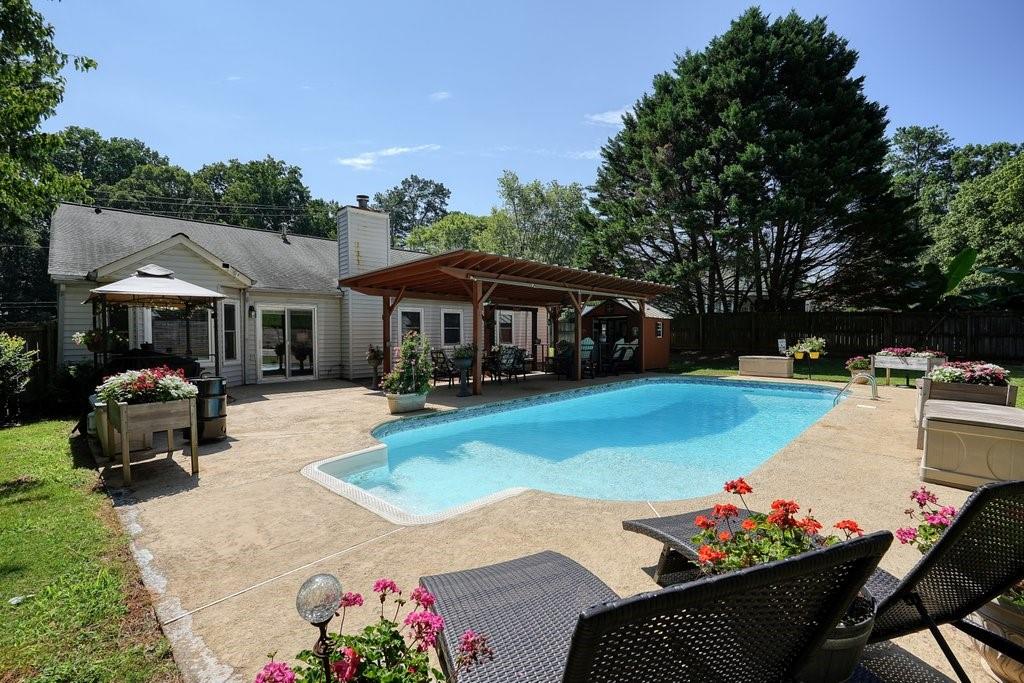 Welcome to your private retreat at 912 River Rock Dr. This charming 3-bedroom, 2-bath ranch home offers not only comfortable living spaces but also an incredible backyard ideal for hosting gatherings and entertaining. The saltwater pool invites relaxation, while the "Pub" area creates a fun atmosphere for evening entertainment. With NO HOA and a 10-year-old roof, you have the freedom to enjoy the property your way. The fully fenced-in yard offers privacy making it the perfect space to entertain or simply enjoy the outdoors. Looking for additional storage? The backyard offers an additional storage building for lawn equipment and an additional shop. Located just minutes from the vibrant cities of Woodstock and Roswell, you’ll find countless parks, best in class dining and shopping, trails, and outdoor activities right at your doorstep. Don't miss out on this exceptional home where every day feels like a getaway! You will not find a better value than what is being offered!