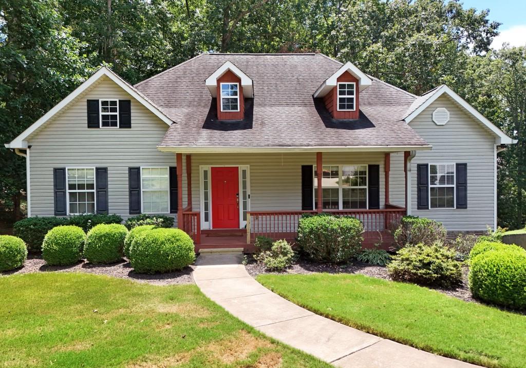 Welcome to this beautifully maintained Craftsman-style ranch nestled on a private, wooded lot! This spacious 4-bedroom, 3-bath home offers the perfect combination of charm, comfort, and functionality. From the inviting front porch and bold red door to the thoughtfully designed interior, you will feel right at home. Inside, enjoy an open, airy floor plan featuring vaulted ceilings, a formal dining room with coffered ceilings and elegant wainscoting, and a cozy living area anchored by a beautiful brick fireplace. The kitchen is outfitted with rich wood cabinetry, a breakfast bar, and a clear view into the main living space, ideal for both entertaining and everyday living. The oversized primary suite provides a private retreat, while the secondary bedrooms are generously sized. Downstairs, a large family room offers the perfect space to relax or host guests, complete with an adjacent bar area, an additional bedroom, and a full bath. Step outside to the elevated back deck, perfect for morning coffee or evening gatherings with peaceful views of the serene, wooded backyard. Situated in a quiet, established neighborhood, this home offers space, style, and flexibility just minutes from local shopping and schools.