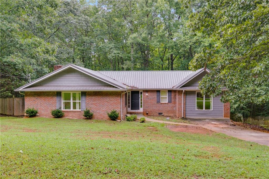 Charming 4-sided brick ranch just minutes from downtown Carrollton and I-20. This 3-bedroom, 2-bath home features a spacious open-concept layout that connects the living area and kitchen, perfect for everyday living and entertaining. The split-bedroom floor plan offers added privacy and flexibility, making it ideal for families or guests. A durable metal roof provides long-term peace of mind, while the large back deck and fully fenced yard create a great outdoor space for relaxing, hosting, or letting kids and pets play. Conveniently located just 10 minutes to both I-20 and downtown Carrollton, this home combines comfort, functionality, and an unbeatable location.