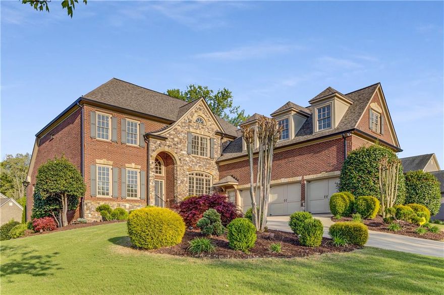 Welcome Home to this stunning former Model Home, a masterpiece of design and detail showcasing premium finishes and thoughtful upgrades at every turn. Situated in the sought-after Hillgrove High School district, this residence offers 7 spacious bedrooms and 5.5 bathrooms, including a luxurious Primary Suite on the Main Level with direct access to the back deck. Step into elegance through a dramatic two-story foyer that sets the tone for the rest of the home. To the right, a formal dining room comfortably seats 12—perfect for hosting special gatherings. Just beyond, the tray-ceiling family room connects seamlessly to a beautifully appointed kitchen featuring granite countertops, a coffee bar, a walk-in pantry, and an open-concept layout ideal for entertaining. The cozy sitting room boasts coffered ceilings, a fireplace, built-in shelving, and stunning floor-to-ceiling windows that fill the space with natural light. Tucked away on the left wing is the serene primary suite with a spa-like bathroom that includes double vanities and a Jacuzzi tub. Enjoy outdoor living with a covered deck and patio, perfect for entertaining or quiet evenings. The main level also features a laundry room and a three-car garage with a 240V electric vehicle charger. Upstairs, you’ll find generously sized secondary bedrooms and a spacious media/flex room with brand new carpet—offering endless possibilities for a playroom, theater, or home office. Downstairs, the fully finished basement spans over 2,200 sqft and includes a home gym, game room with bar and pool table, separate living area, two additional bedrooms, bonus room, an accessible full bath, full kitchen, and a secondary laundry closet—making it ideal for multigenerational living or guest accommodations. A large unfinished room provides even more storage or project space. Set on a beautifully landscaped corner lot directly across from the neighborhood pool and playground, this home is a rare combination of luxury, space, and unbeatable location in the heart of West Cobb.